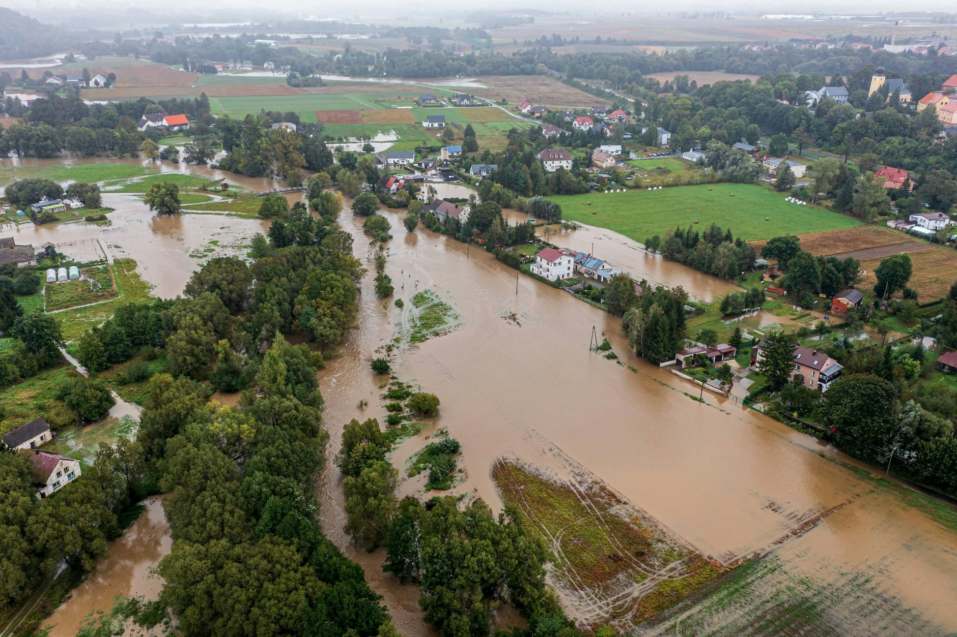 Land unter in Polen: Ein mit einer Drohne aufgenommenes Luftbild zeigt eine geflutete Ortschaft des Landes. Das Hochwasser in Polen bedroht nun auch Brandenburg.