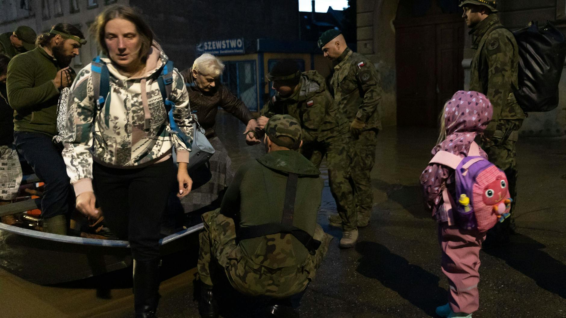 In Klodzko (Polen) holen Soldaten Einwohner aus ihren Häusern, bringen sie mit Booten in Sicherheit.