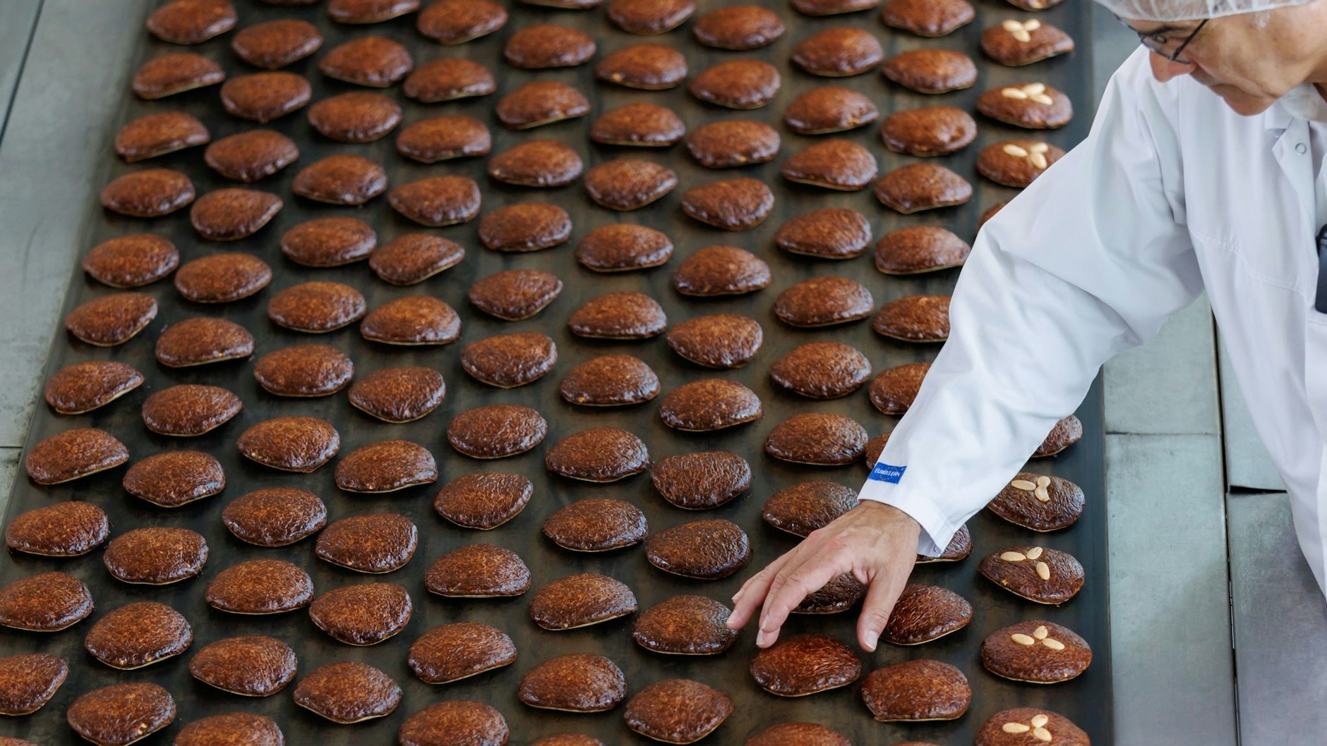 Die Produktion läuft auf vollen Touren: Frisch gebackene Lebkuchen aus dem Ofen liegen hier in einer Fabrik auf einem Band.