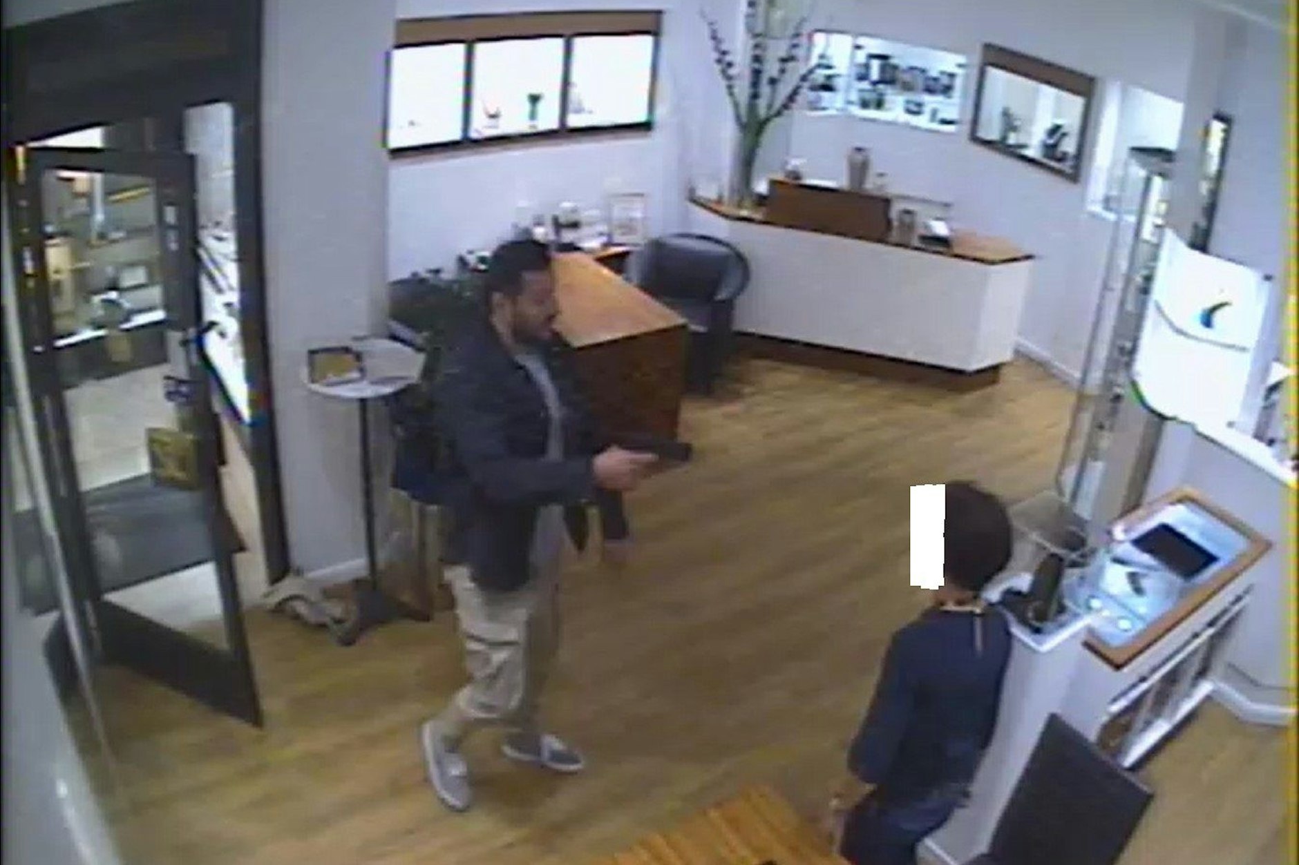 Einer der Räuber betritt mit einer Pistole bewaffnet den Juwelier