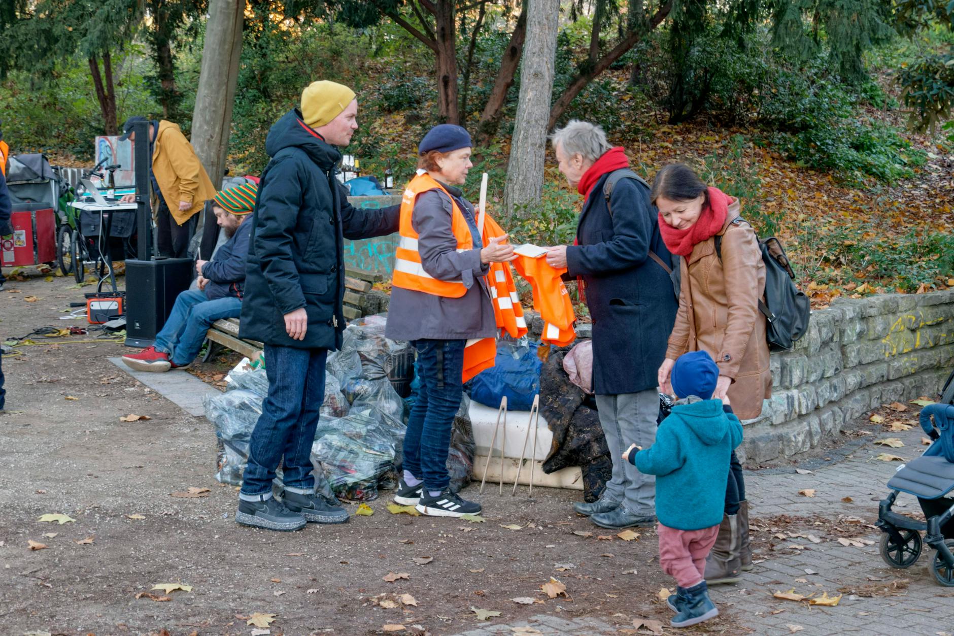Menschen sammeln gemeinsam Müll in einem Park in Berlin.