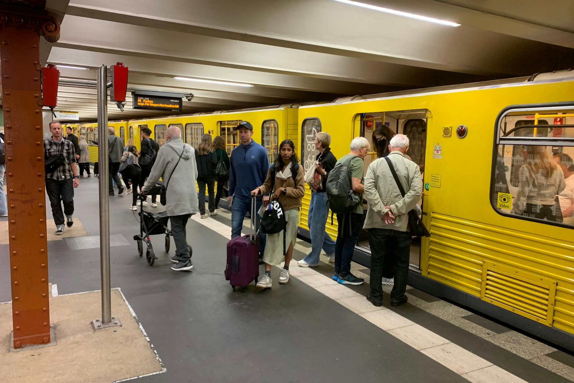 Volle Züge im U-Bahnhof Alexanderplatz: Auf einem Laufband im digitalen Zuganzeiger entschuldigt sich die BVG für längere Wartezeiten auf der U2.