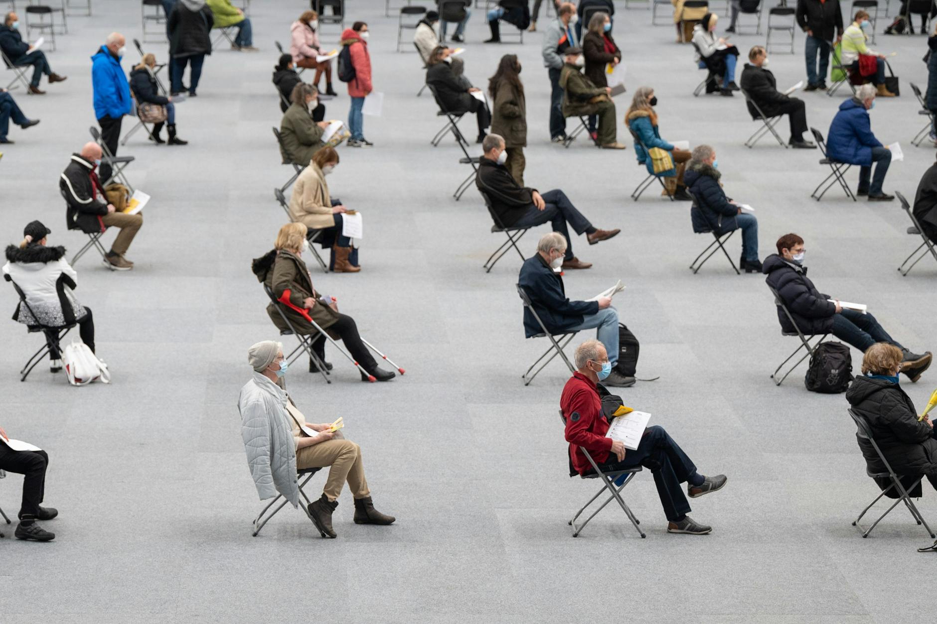 Menschen sitzen am ersten Tag des Impfmarathons in der August-Schärttner-Halle und warten darauf, dass sie geimpft werden. 