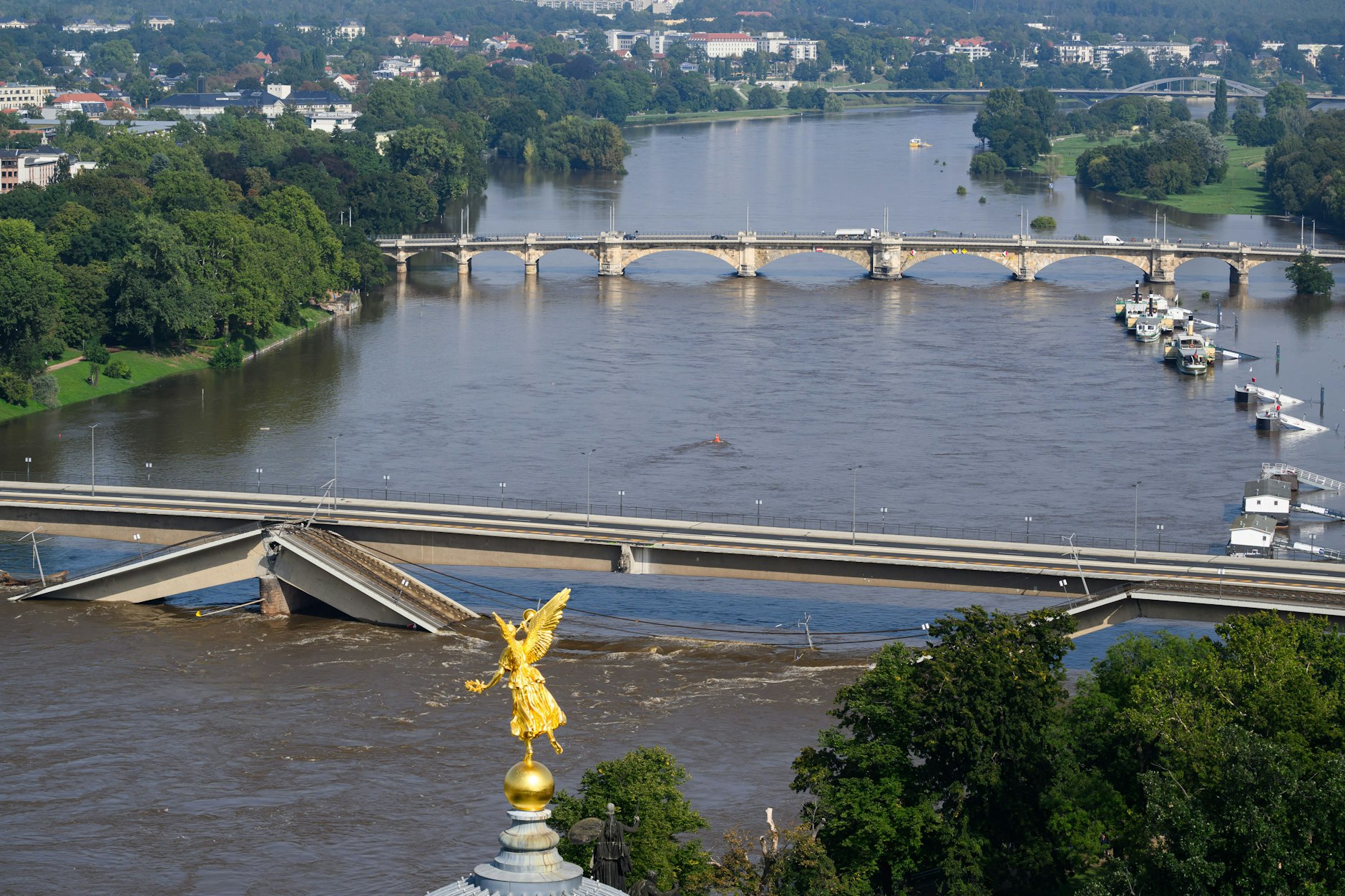 Die Hochwasser führende Elbe fließt an der zum Teil eingestürzten Carolabrücke entlang, im Vordergrund ist der Engel „Fama“ auf der Kunstakademie zu sehen.