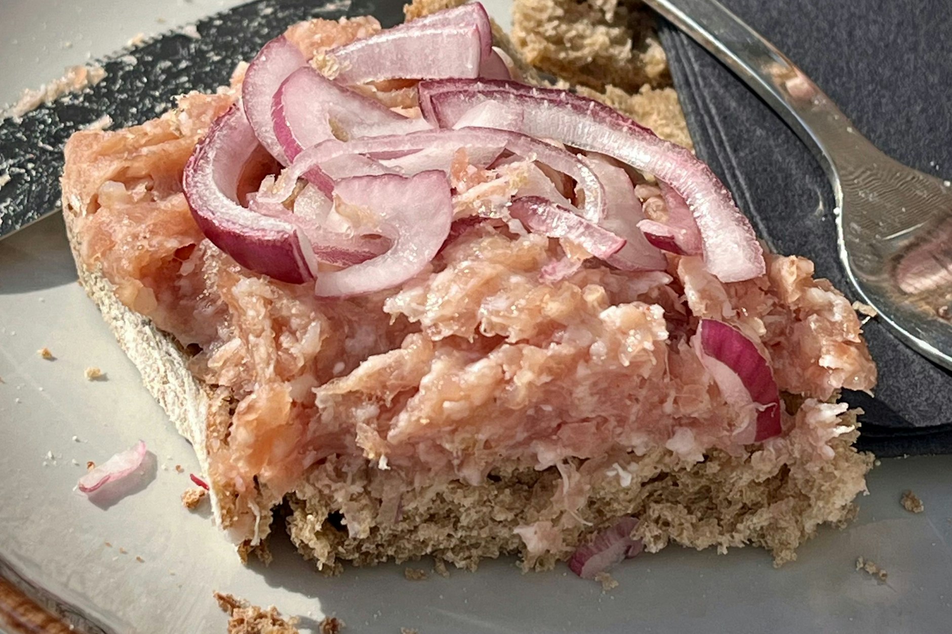 Eine klassische Mettstulle, wie man sie nur in Berlin bekommt: rustikales Roggenbrot, saftiges Mett in zartem Rosa, dazu scharf-frische Zwiebelringe. Ein einfacher Genuss, der jeden Imbissbesuch unvergesslich macht, diese Mettstulle wurde beim Pressecafé mit Aussicht auf den Fernsehturm verzehrt – Hier ein originales KURIER-Rezept!