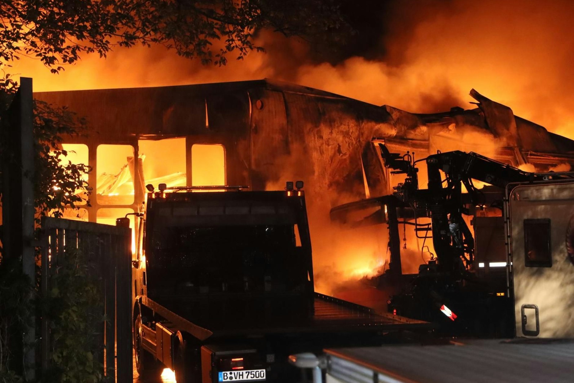 Der vollständig ausgebrannte Hallenkomplex nach dem Einsatz. Nur noch verkohlte Trümmer und ausgebrannte Fahrzeugwracks sind übrig.