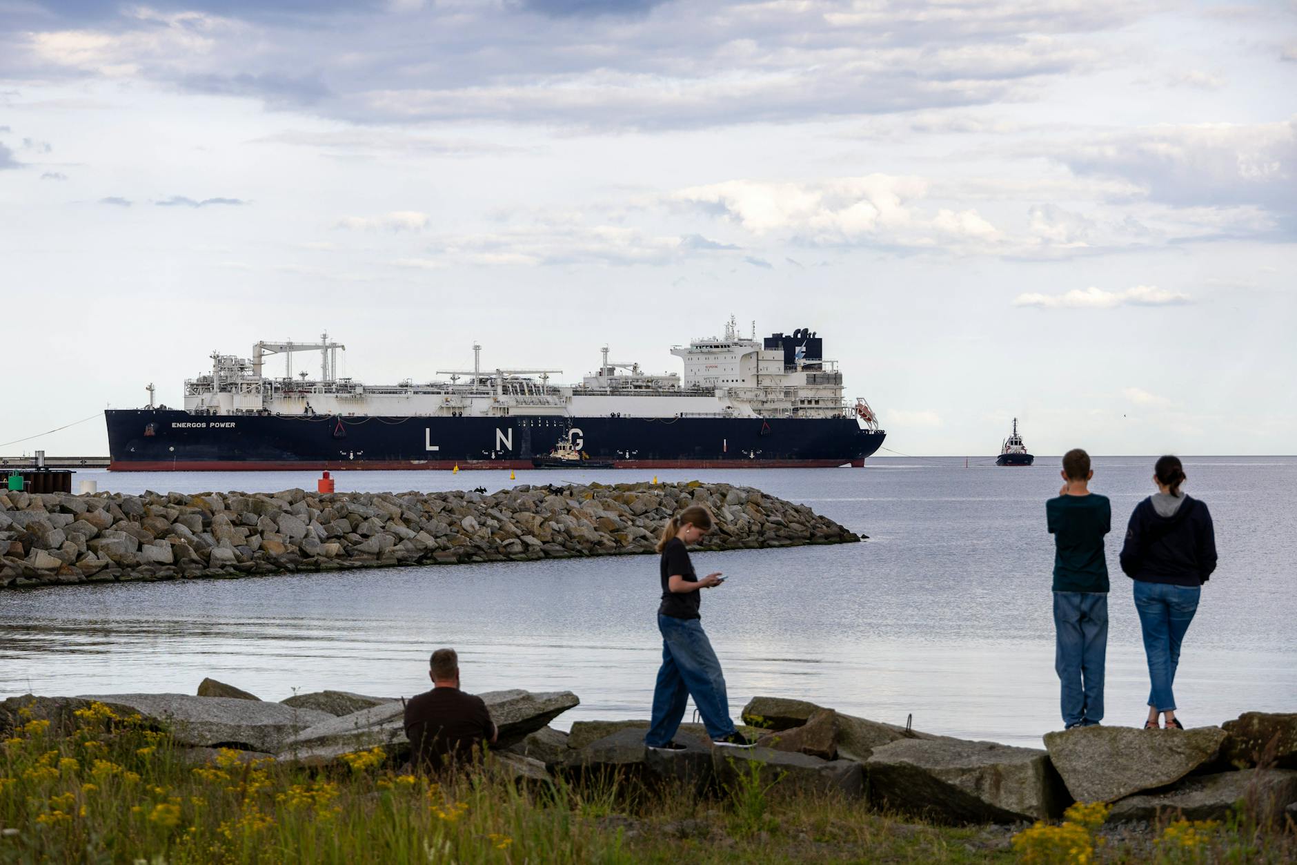 Touristen beobachten die Einfahrt eines Regasifizierungsschiffes in den Hafen Mukran auf der Insel Rügen.