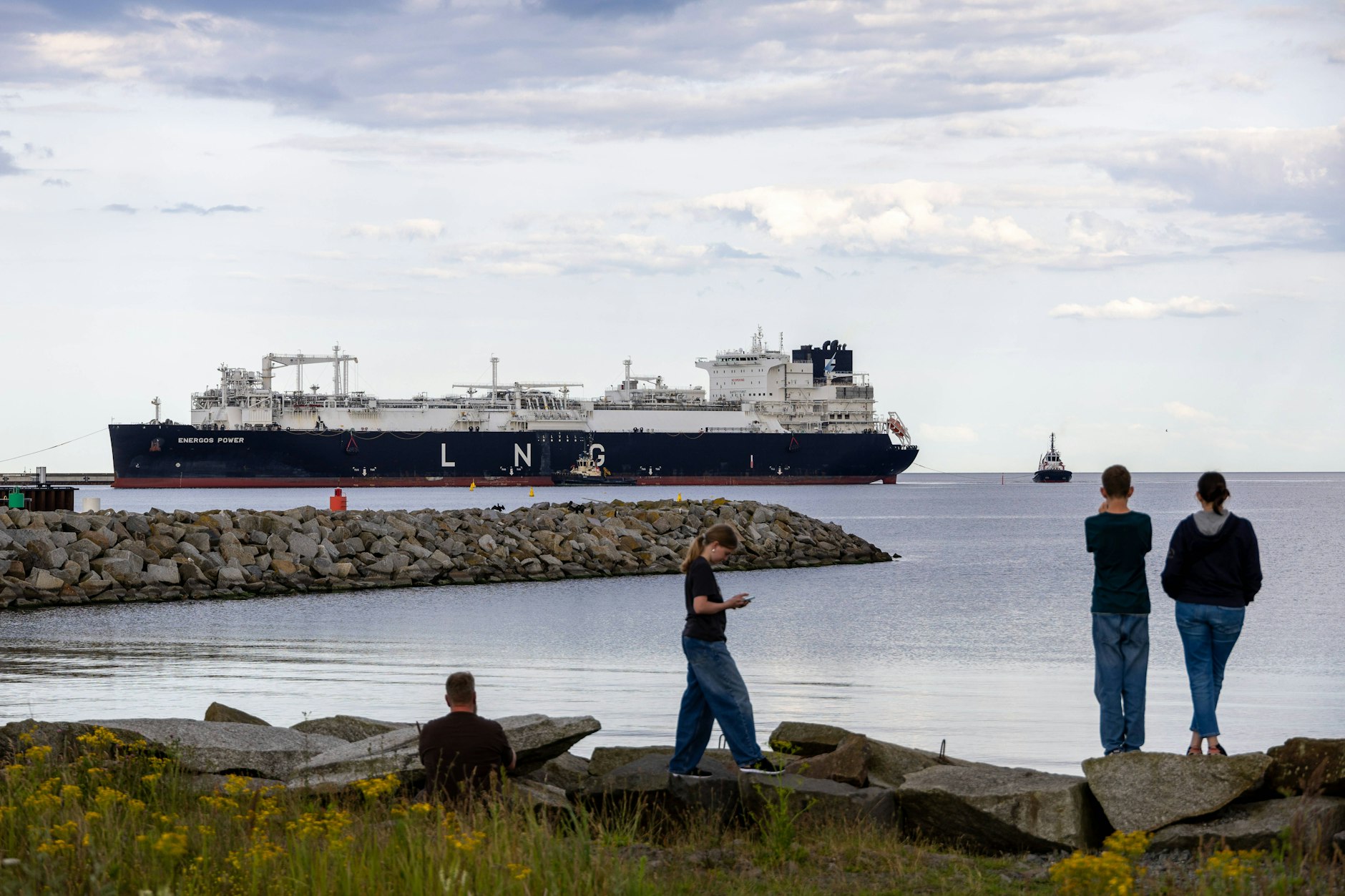 Touristen beobachten die Einfahrt eines Regasifizierungsschiffes in den Hafen Mukran auf der Insel Rügen.