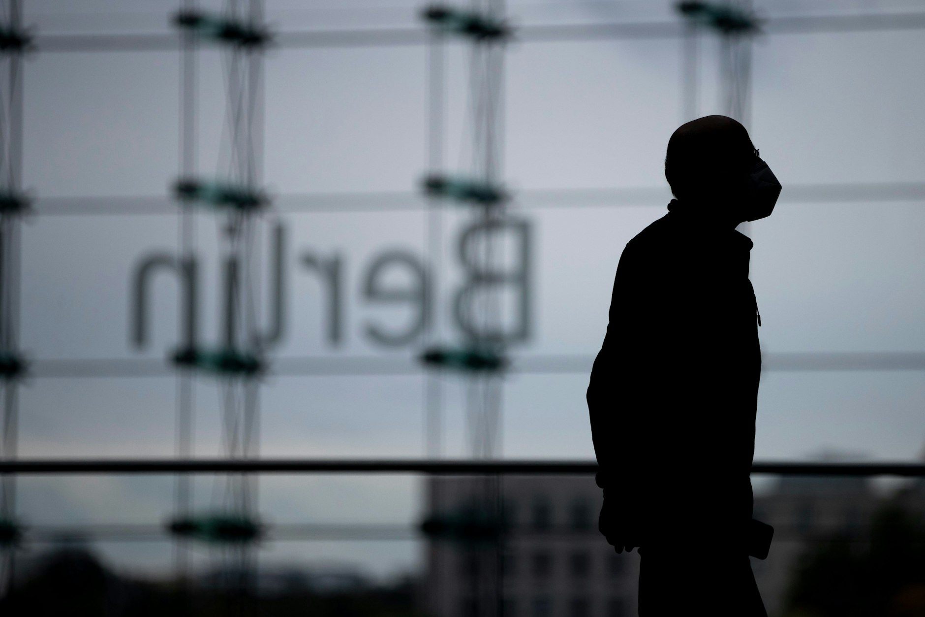 Ein Mann mit Schutzmaske geht während der Corona-Pandemie durch den Berliner Hauptbahnhof.