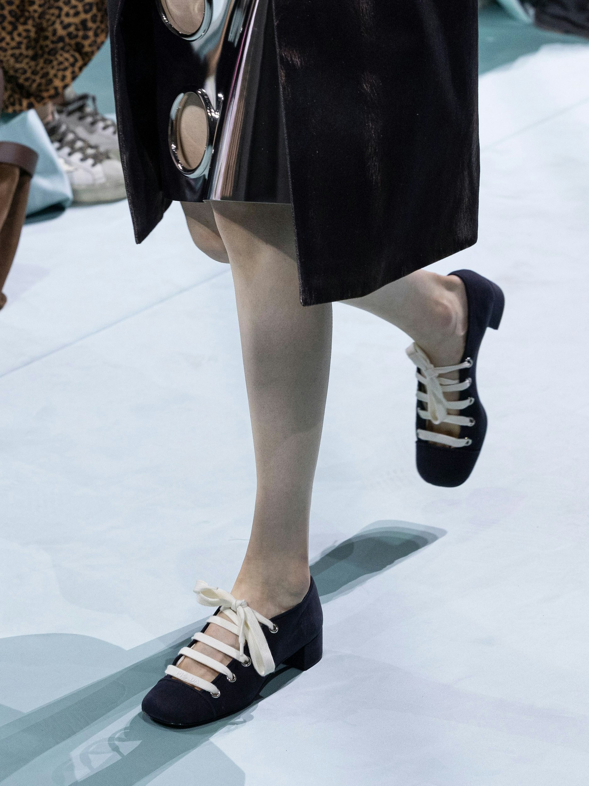 Eine Fusion aus Pump und Ballerina, samt Stoffband zum Schnüren. Das sieht sehr nach Miuccia Pradas Vorliebe für wilde Mädchenlooks aus.