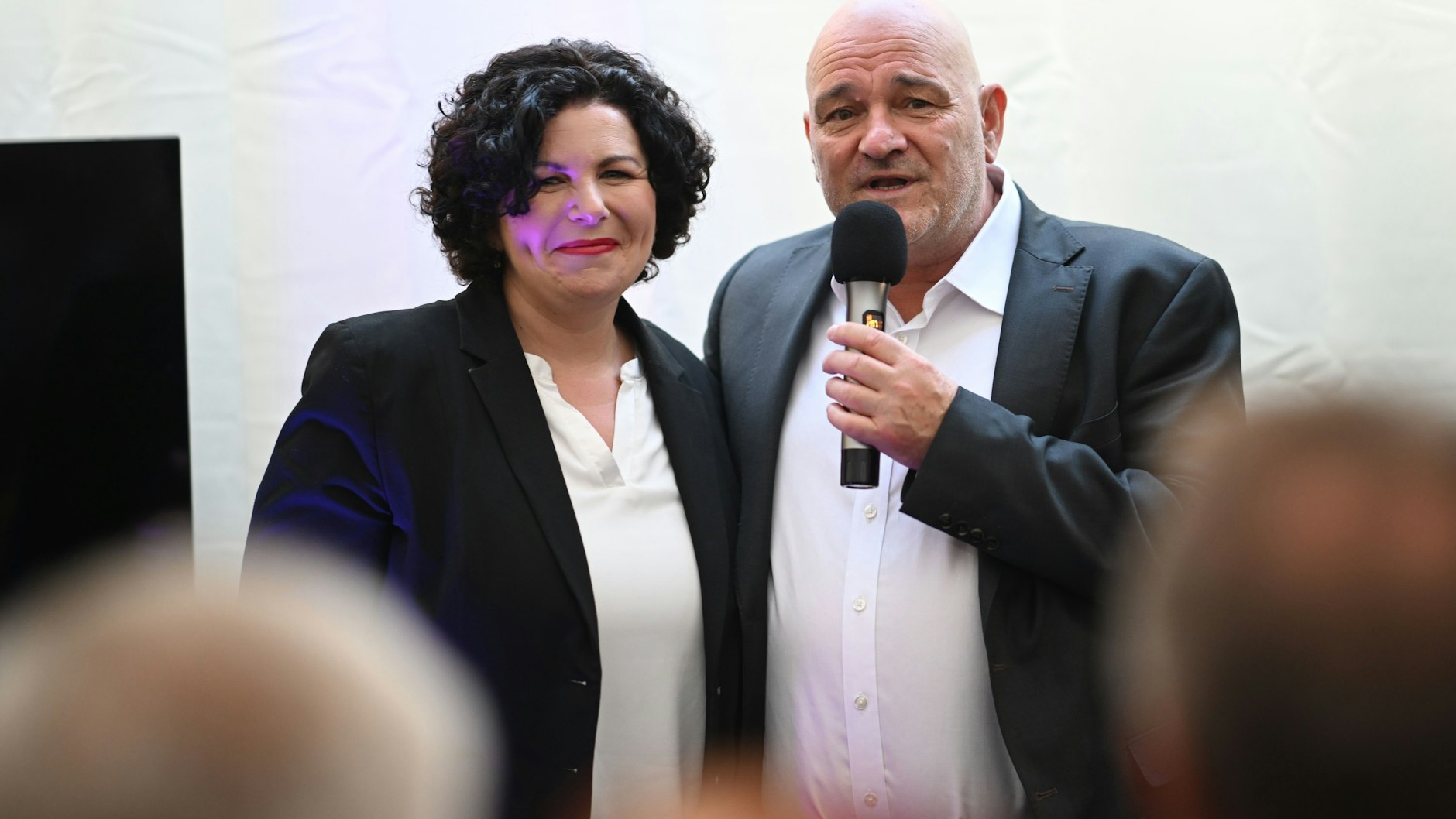 Robert Crumbach, Spitzenkandidat des Bündnis Sahra Wagenknecht (BSW) in Brandenburg, und Amira Mohamed Ali, Co-Vorsitzende des BSW, sprechen gemeinsam auf der Bühne bei der Wahlparty des BSW. 