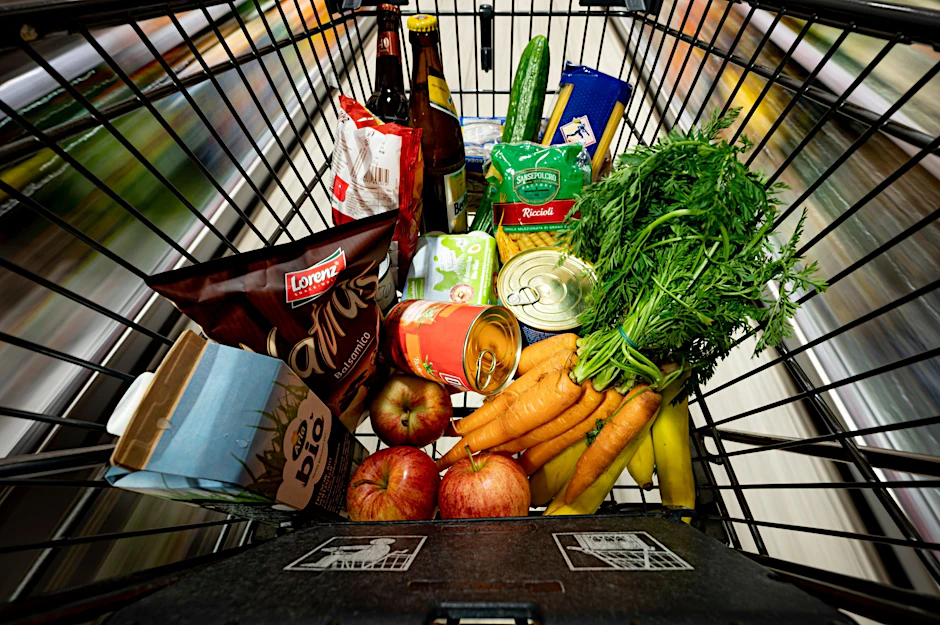 Lebensmittel liegen in einem Einkaufswagen in einem Supermarkt.