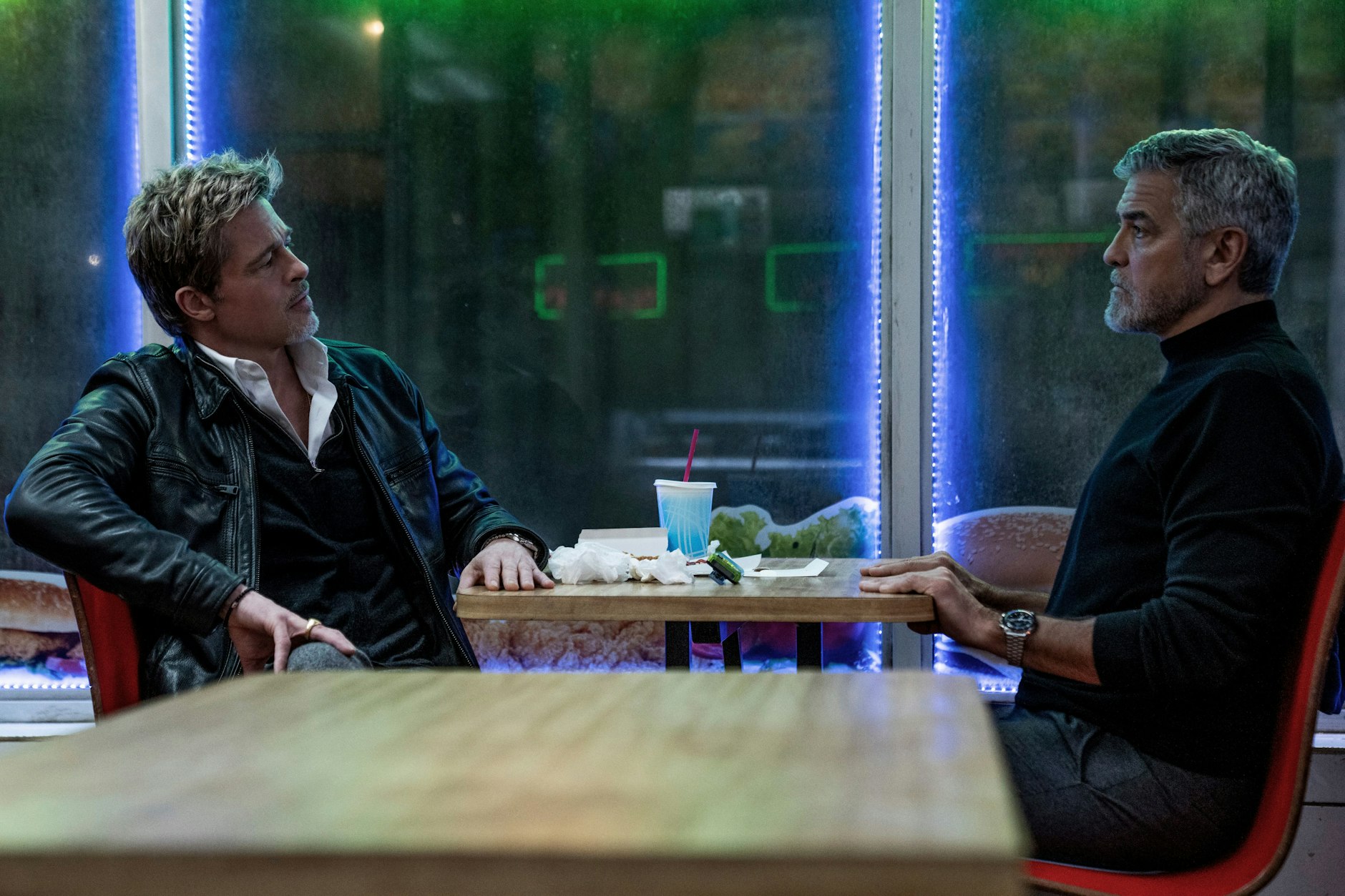 Brad Pitt (l.) und George Clooney in einer Szene ihres neuen Films „Wolfs“.