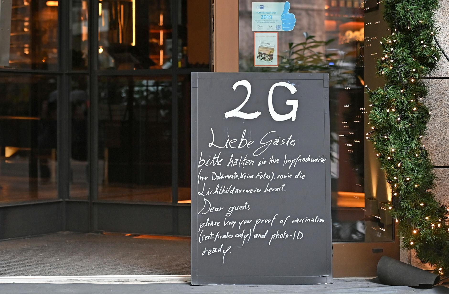 Ein Schild weißt auf die 2G-Regel in einem Restaurant in München hin.