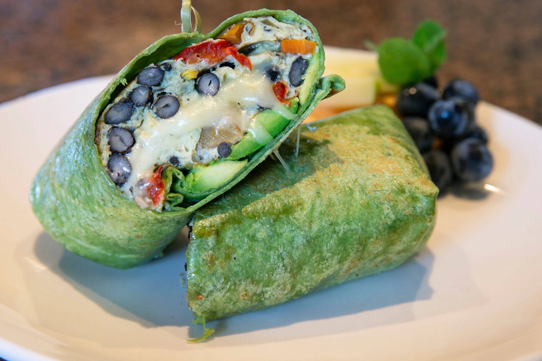 Ein leckerer Frühstücks-Burrito mit Käse, schwarzen Bohnen und Avocado macht den Tag gleich viel besser.