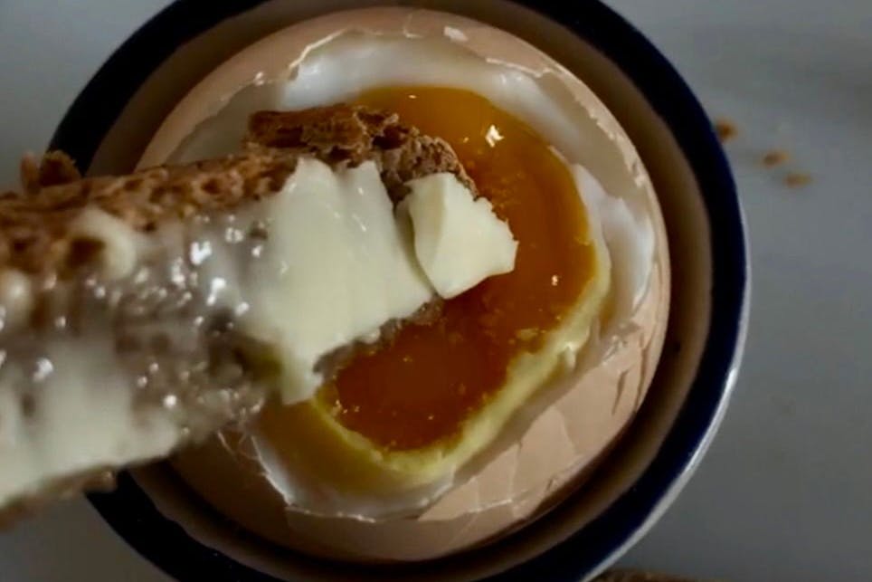 Ein echter Hofgenuss: Das frisch gekochte Ei mit flüssigem Eigelb wird perfekt, wenn knusprige Sauerteigbrotstreifen, großzügig mit schwedischer Butter und einem Hauch Mayonnaise bestrichen, hineingetunkt werden. Diese cremig-salzige Kombination bringt das goldene Eigelb voll zur Geltung.