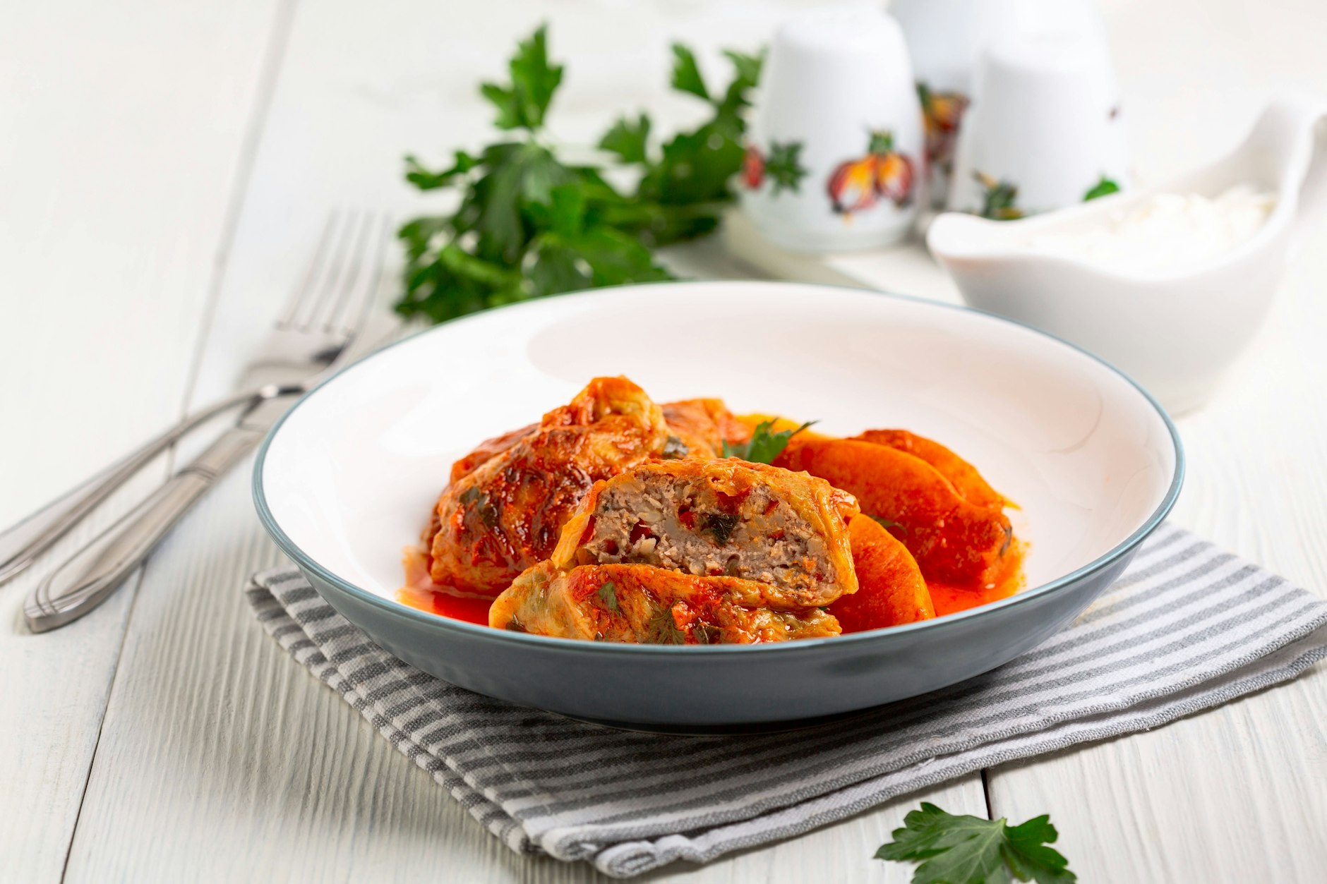 Spitzkohl-Rouladen mit Hackfleisch, serviert mit leckerer Soße sind ein traditionelles deutsches Gericht. Der Spitzkohl ist gesund und das Hackfleisch schmeckt deftig.