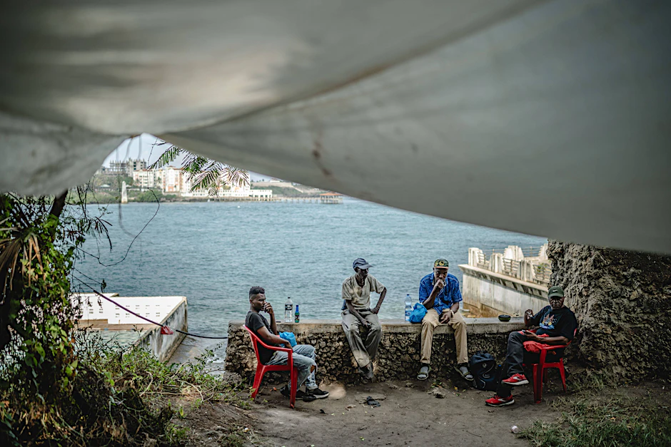 Menschen sitzen an der Küste in Mombasa, Kenya.