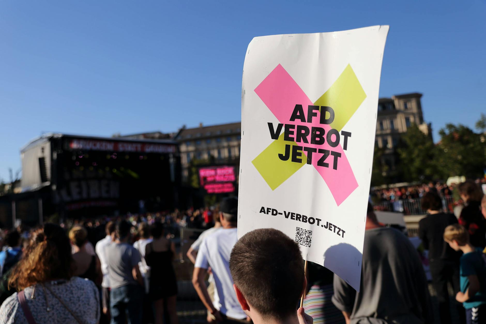 Ein Demonstrant fordert "AfD Verbot Jetzt" während einer Kundgebung in Potsdam.