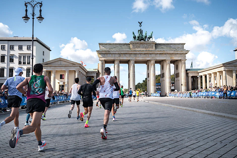 So viele Läufer wie noch nie rennen beim 50. Berlin-Marathon durch das Brandenburger Tor Richtung Ziel.