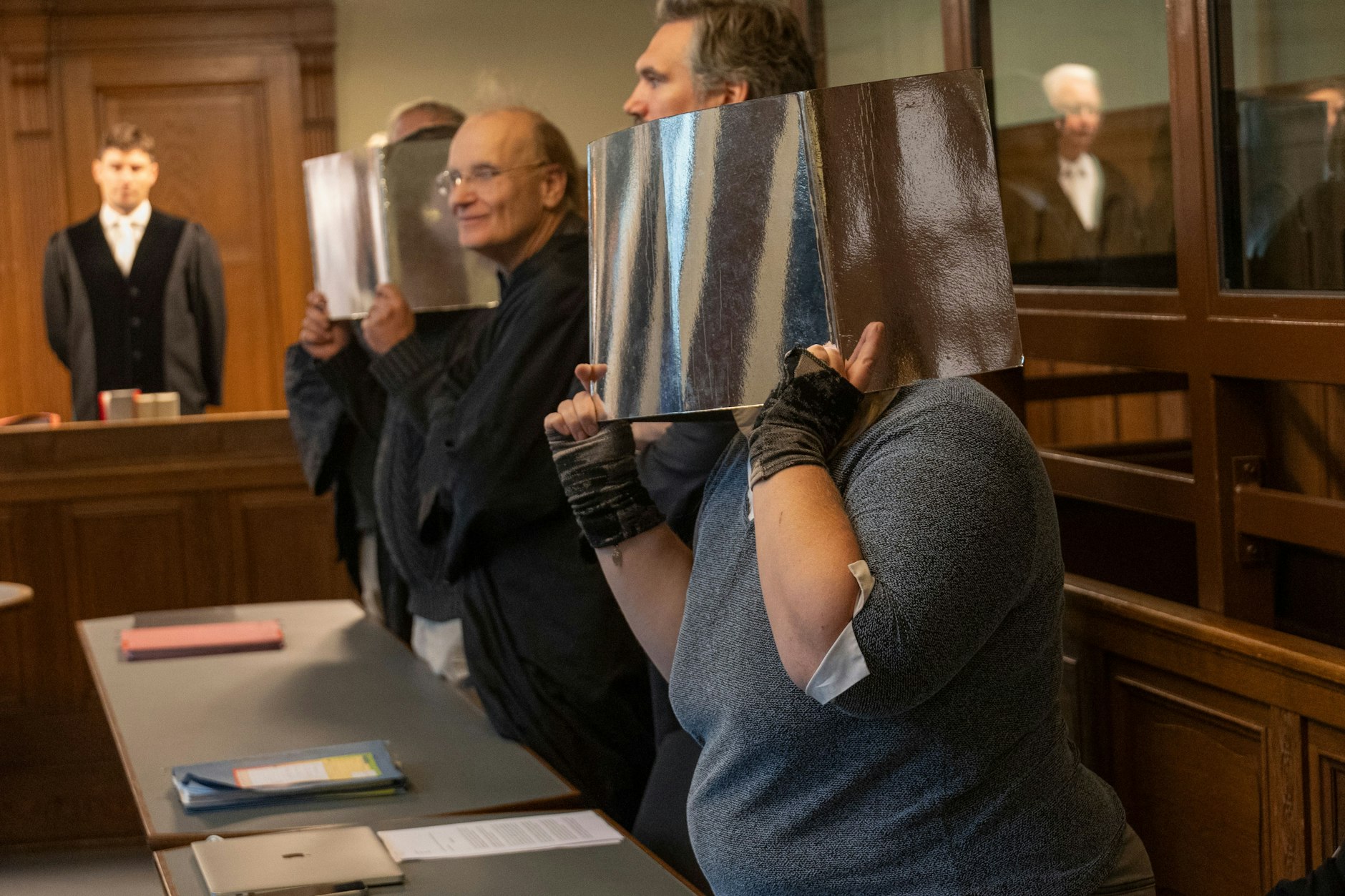 Die beiden Angeklagten (verdeckt) mit ihren Anwälten vor Gericht.