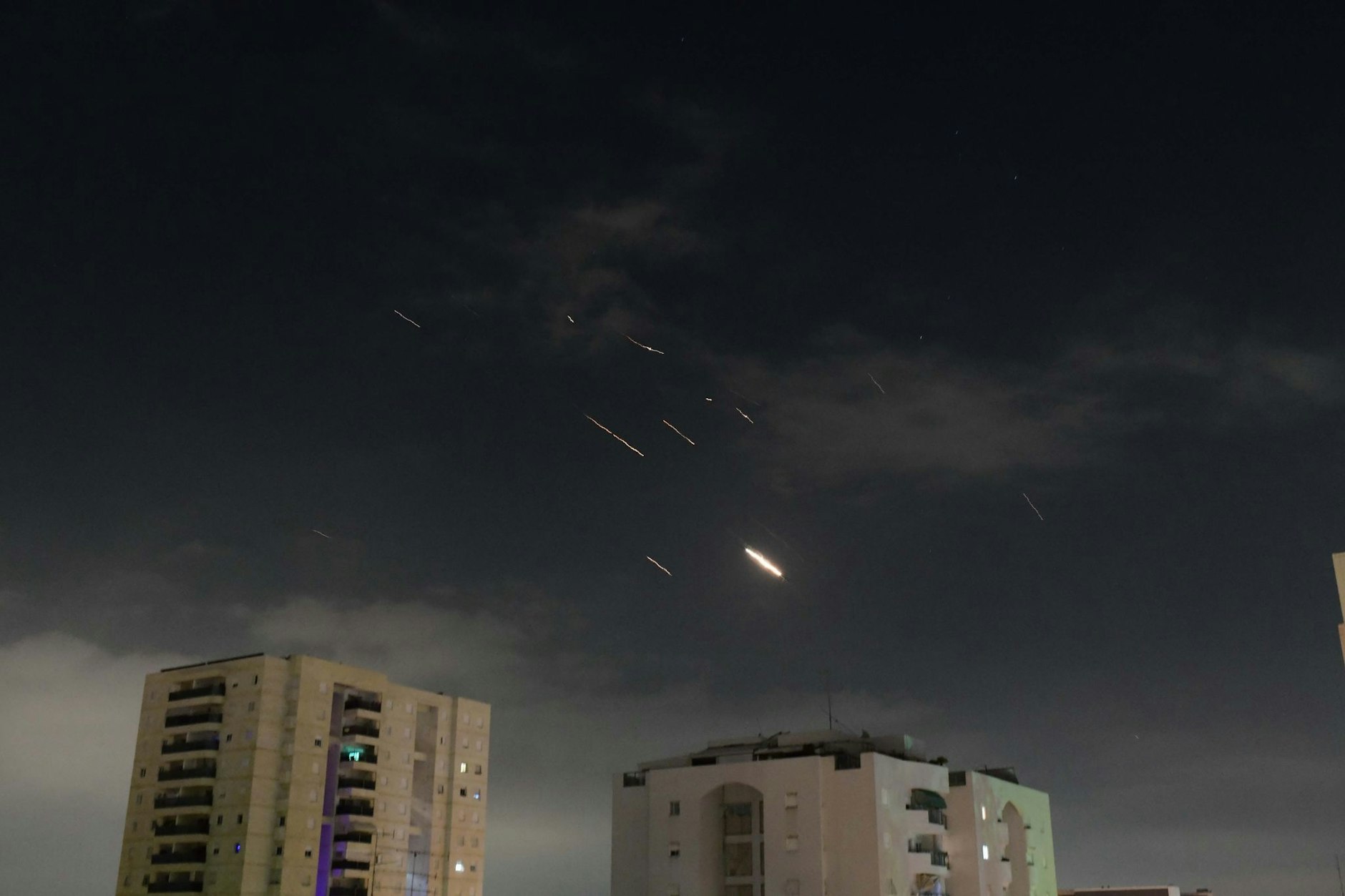 Flammen von Explosionen erscheinen am Himmel über Tel Aviv, während Israels Raketenabwehrsystem Raketen und Drohnen aus dem Iran abfängt.
