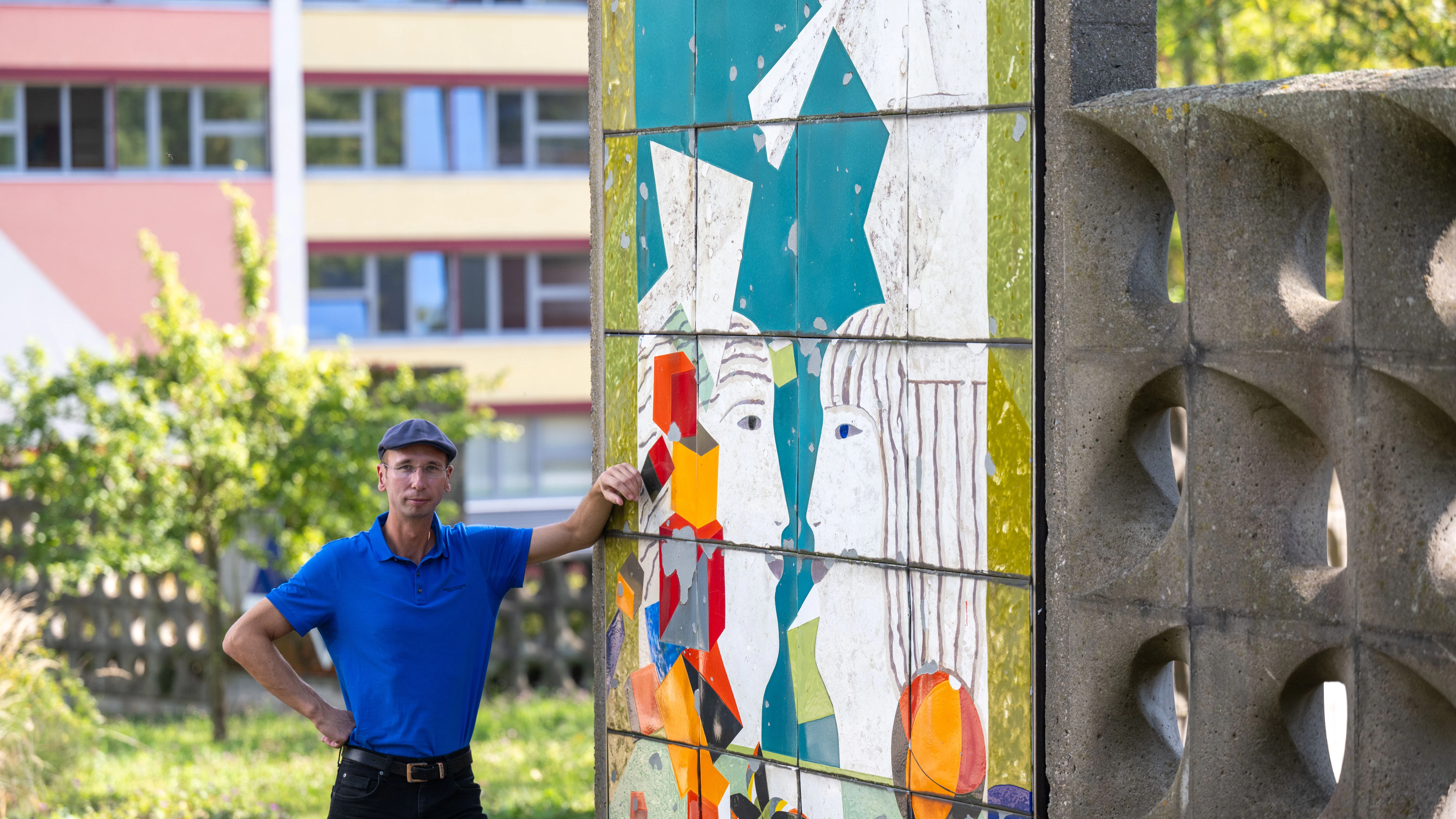 Norbert Engst steht im Heckert Gebiet in Chemnitz neben der Arbeit „Zwiegespräch“ von Uwe Bösch, die als Kunst im öffentlichen Raum einen Boulevard schmückt. Als Autor und Chronist befasst er sich mit der Geschichte des Plattenbaugebiets.