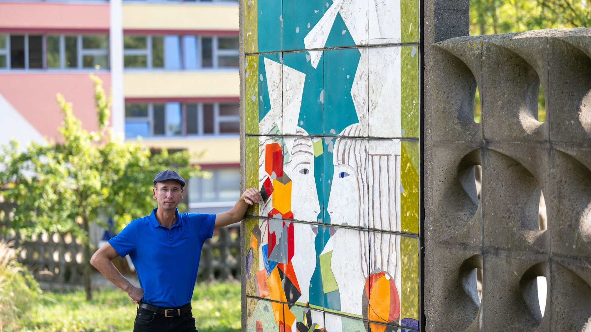 Norbert Engst steht im Heckert Gebiet in Chemnitz neben der Arbeit „Zwiegespräch“ von Uwe Bösch, die als Kunst im öffentlichen Raum einen Boulevard schmückt. Als Autor und Chronist befasst er sich mit der Geschichte des Plattenbaugebiets.