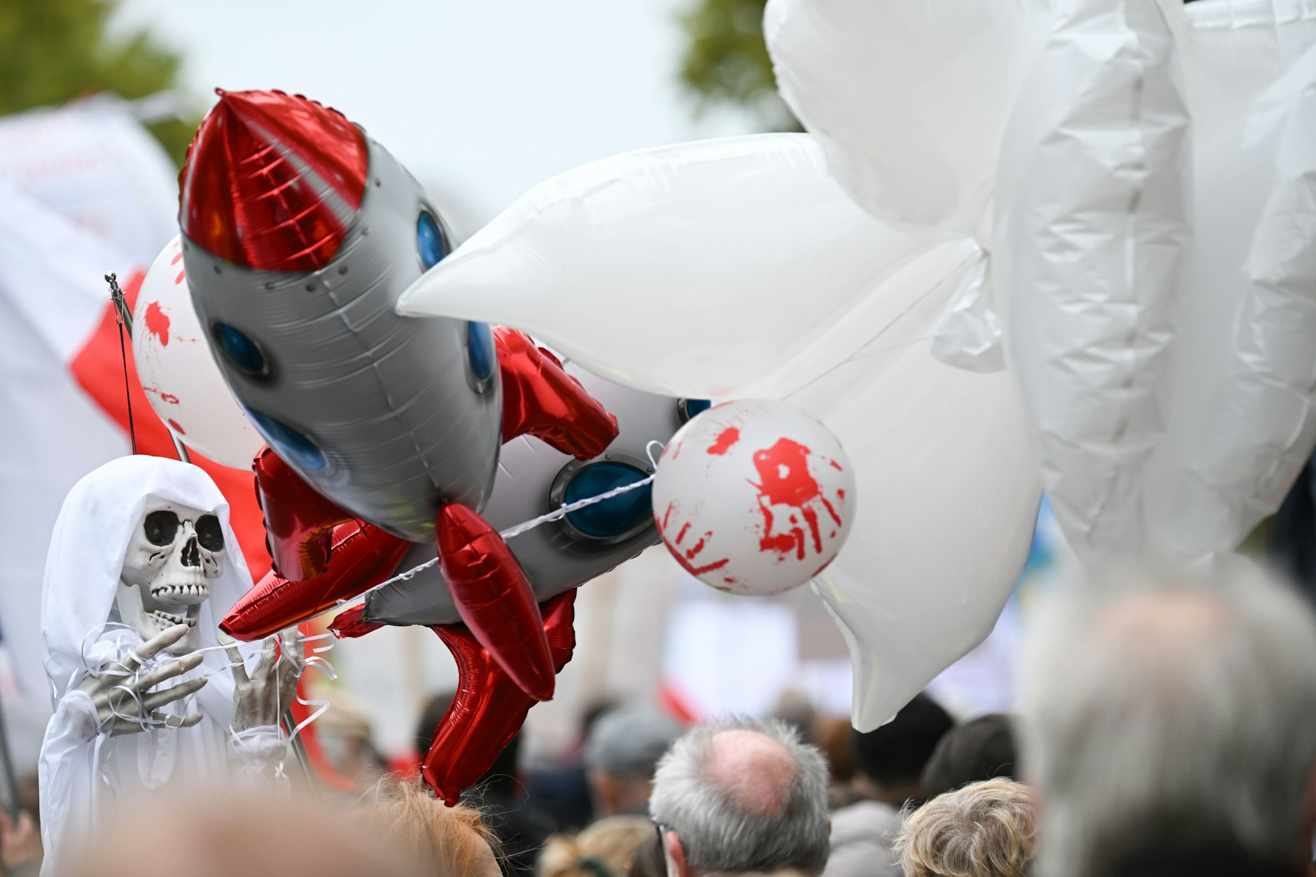 Eine Frau trug ein Skelett mit Luftballons in Form eines Skeletts, einer Rakete und einem Ballon mit Handabdrücken.