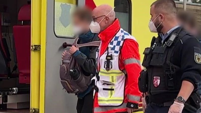 Einsatzkräfte mit Mundschutz begleiten den Medizinstudenten und seine Freundin zum Rettungswagen in Hamburg. Haben die sich mit dem Marburg-Virus infiziert?