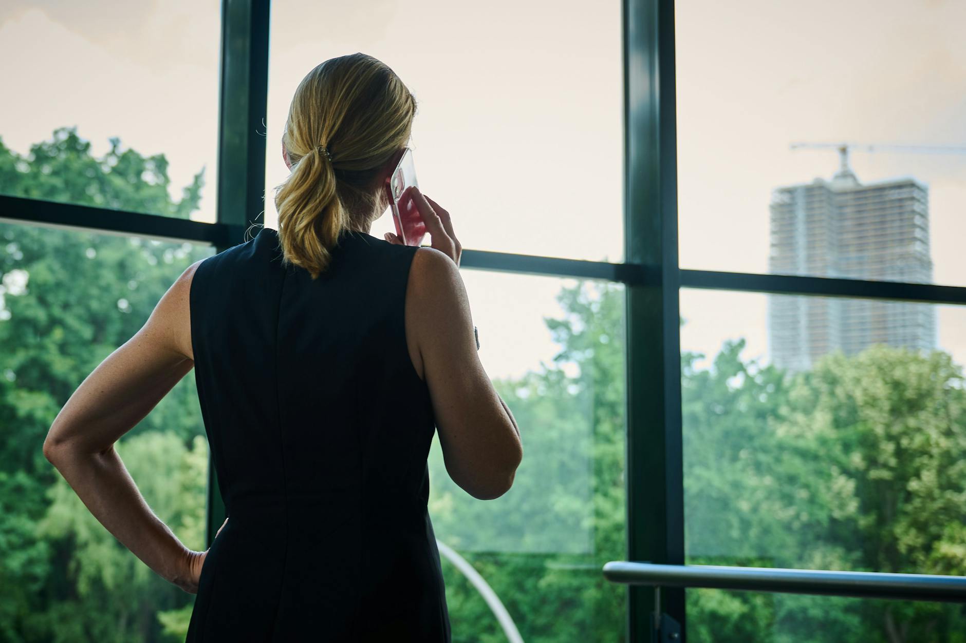 Eine Frau steht vor einem Fenster und telefoniert.