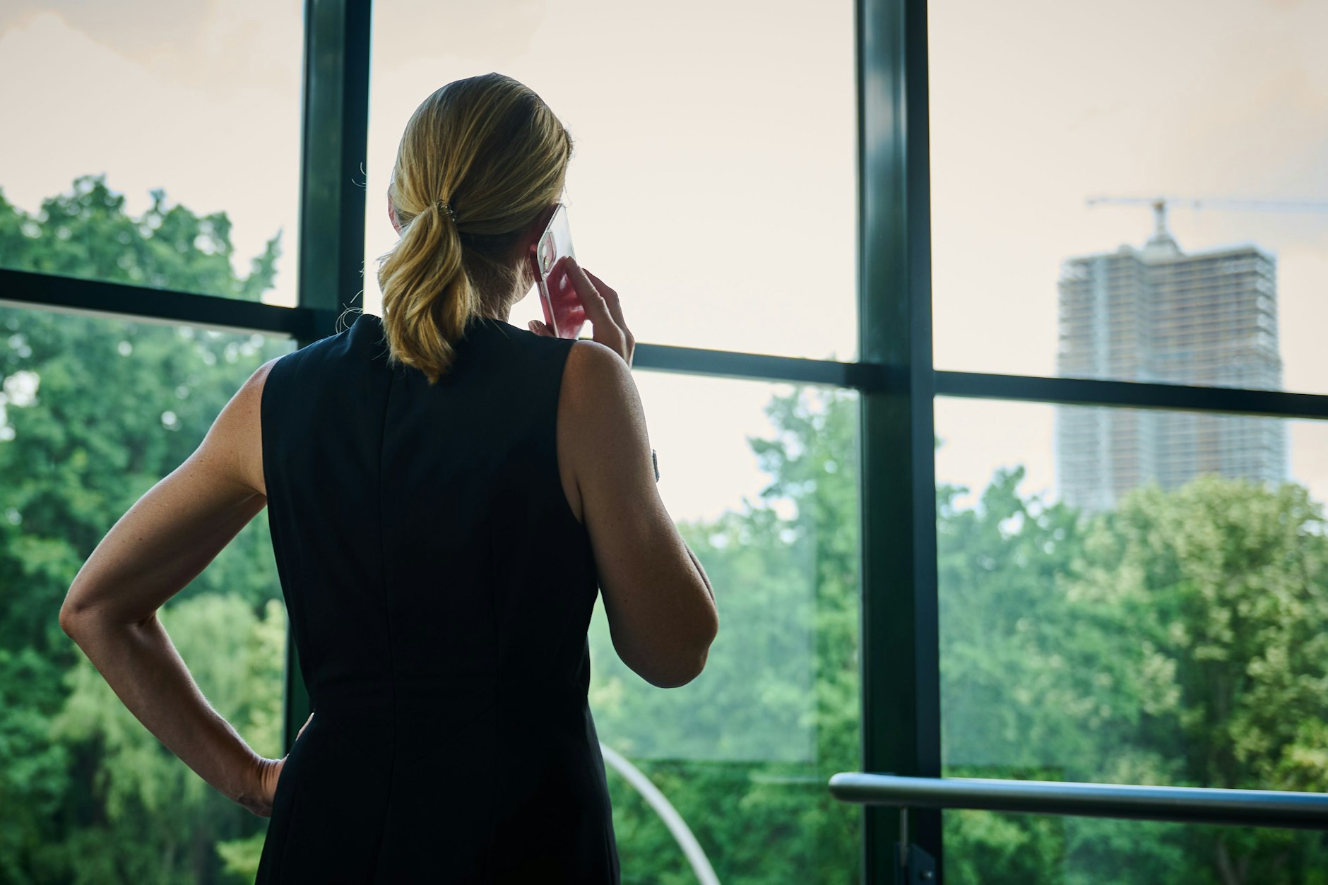 Eine Frau steht vor einem Fenster und telefoniert.