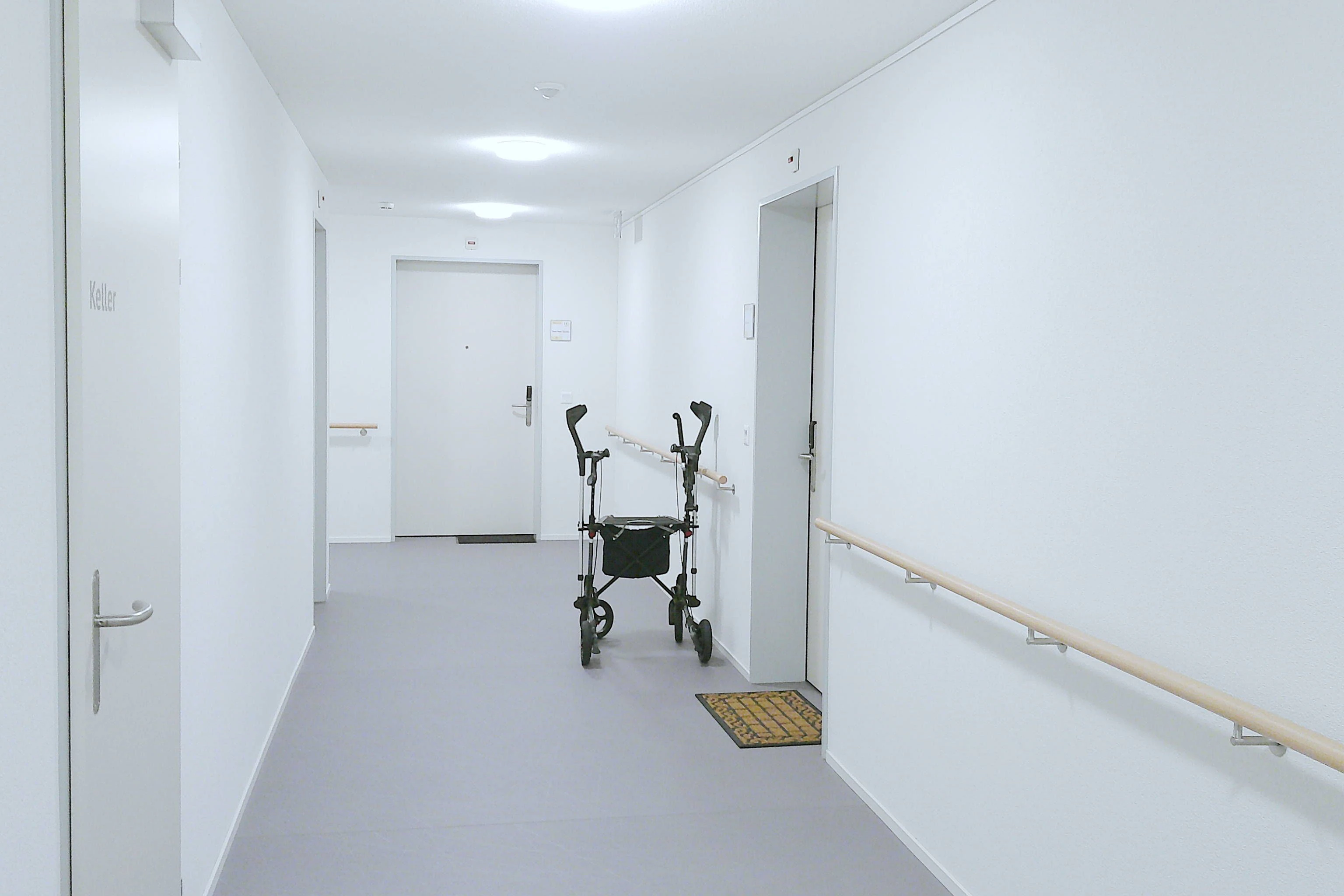 Rollator und Gehhilfen stehen vor einer Zimmertür.