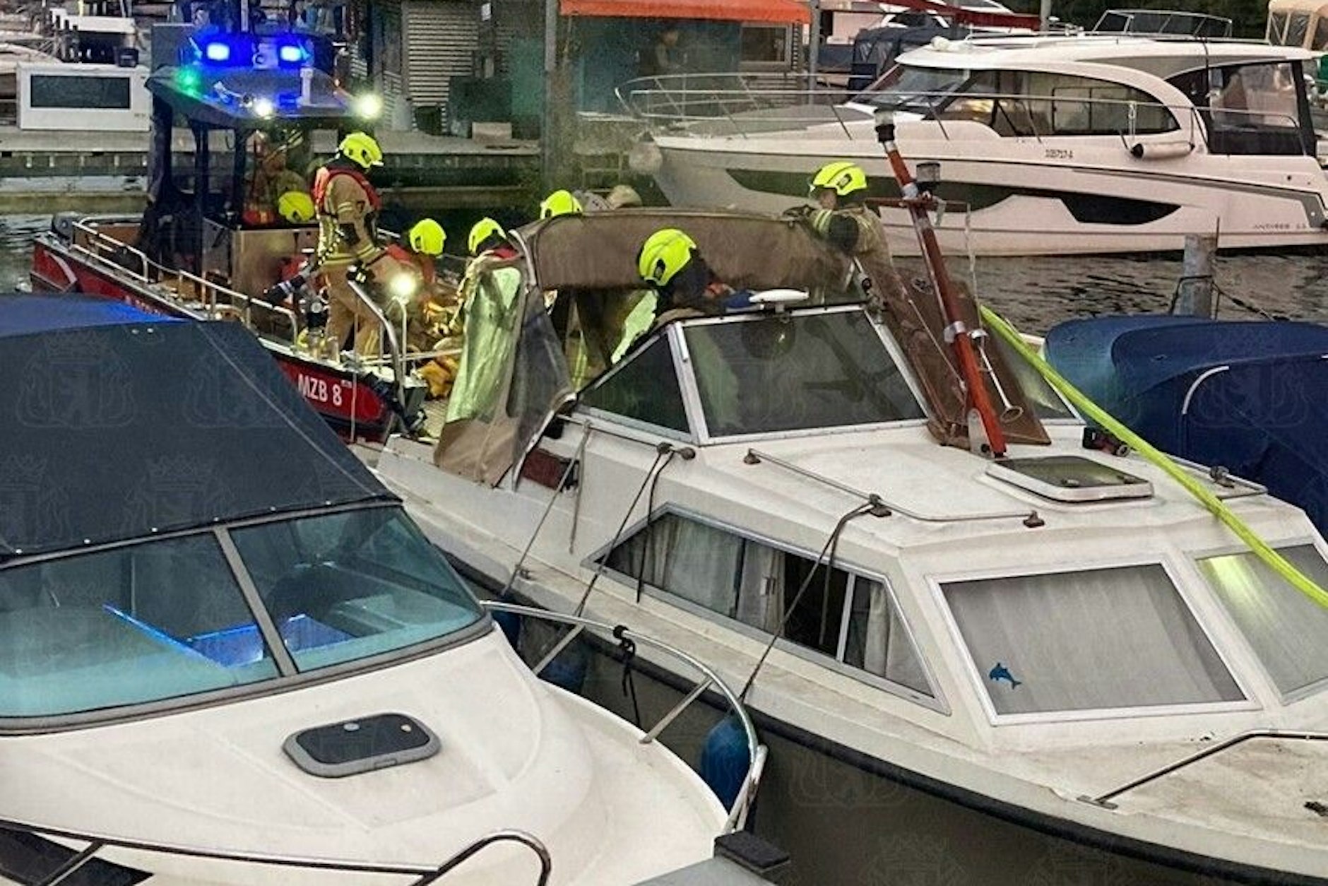 Feuerwehrleute löschen am Samstagabend das Motorboot an einem Steg im Ortsteil Friedrichshagen.