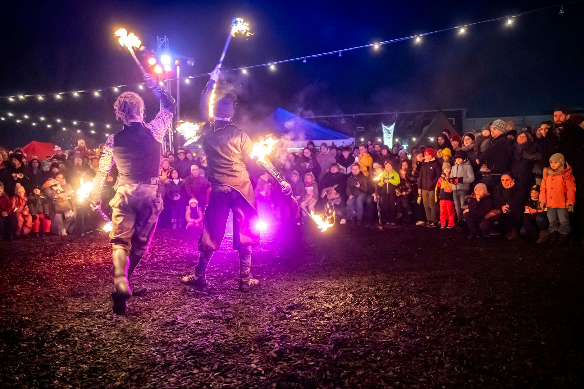 Gaukler und Akrobaten ziehen über den Weihnachtsmarkt am RAW-Gelände.