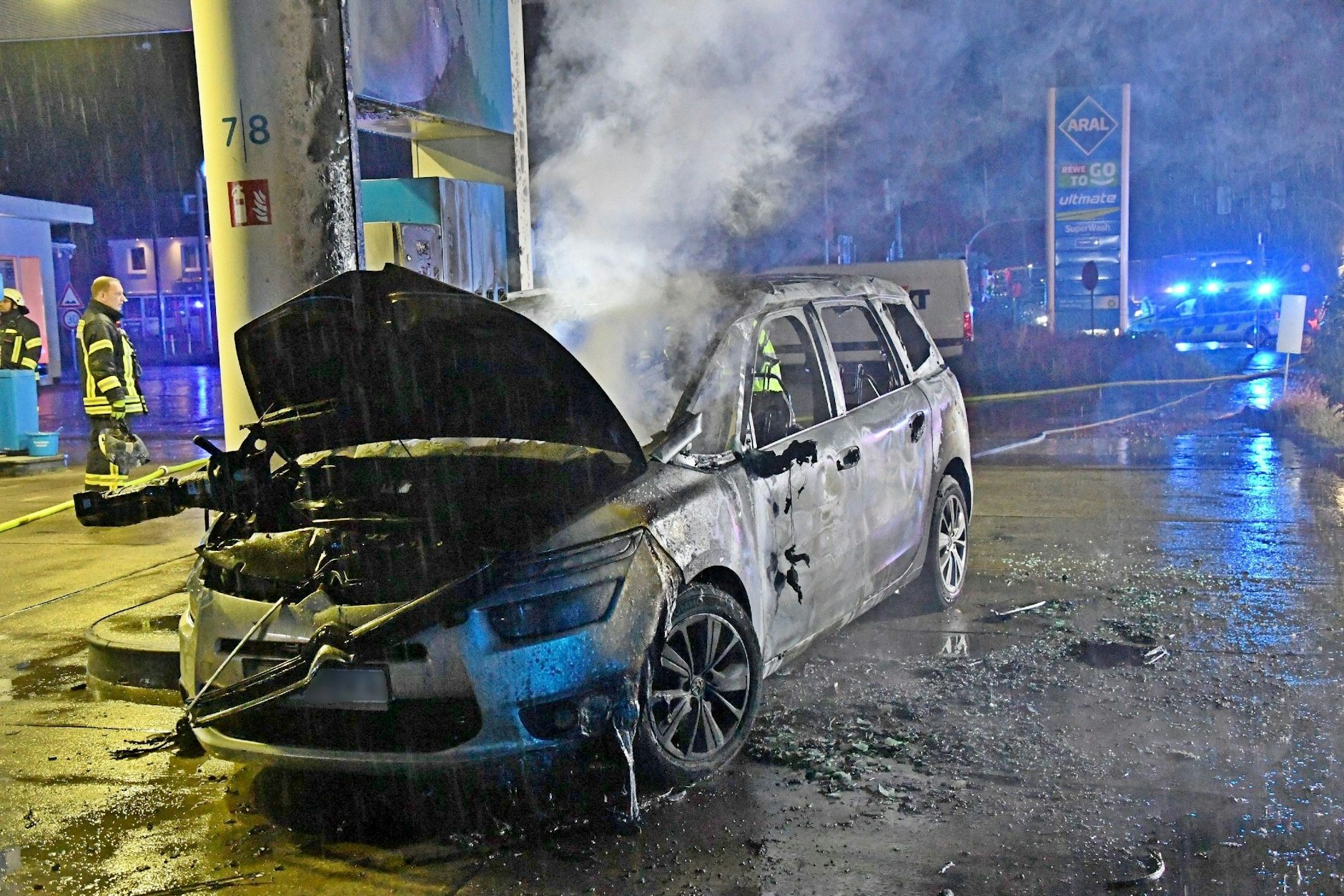 Das ausgebrannte Autowrack steht an einer Tankstelle in Gütersloh. 