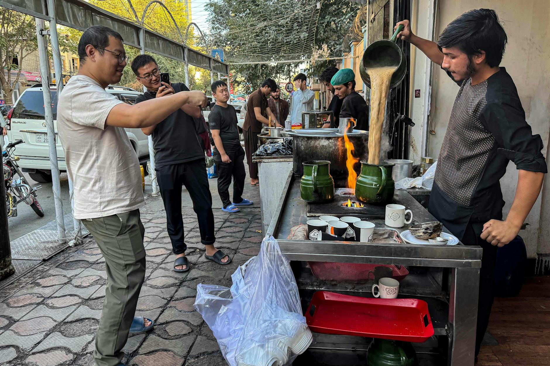 Teezeremonie für die Gäste: Chinesen fotografieren einen Verkäufer vor einem Lokal in Kabul.