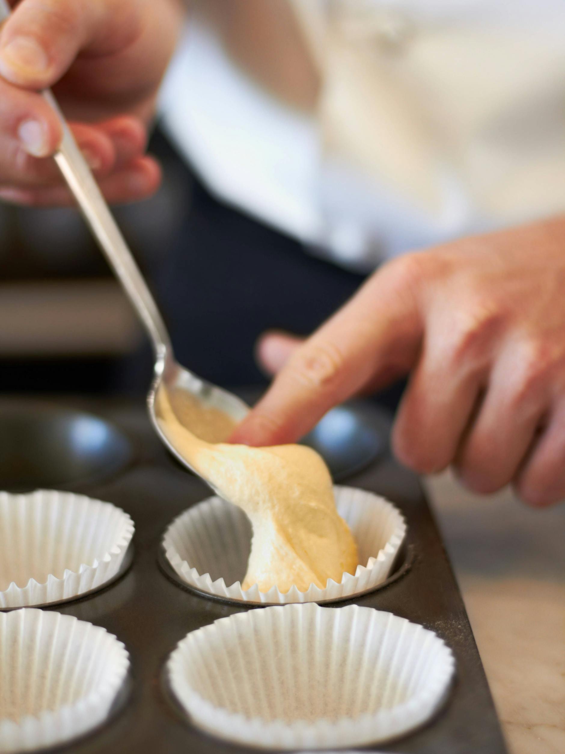 Das Einfüllen des Muffin-Teigs gelingt mit dem Finger, noch besser aber mit zwei Esslöffeln oder einem Eisportionierer.