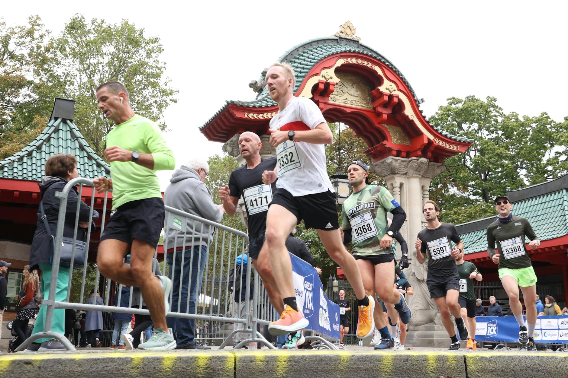 15.10.2023 – Läufer passieren das beeindruckende Elefanten-Tor am Berliner Zoo während des „degewo Great 10K“.