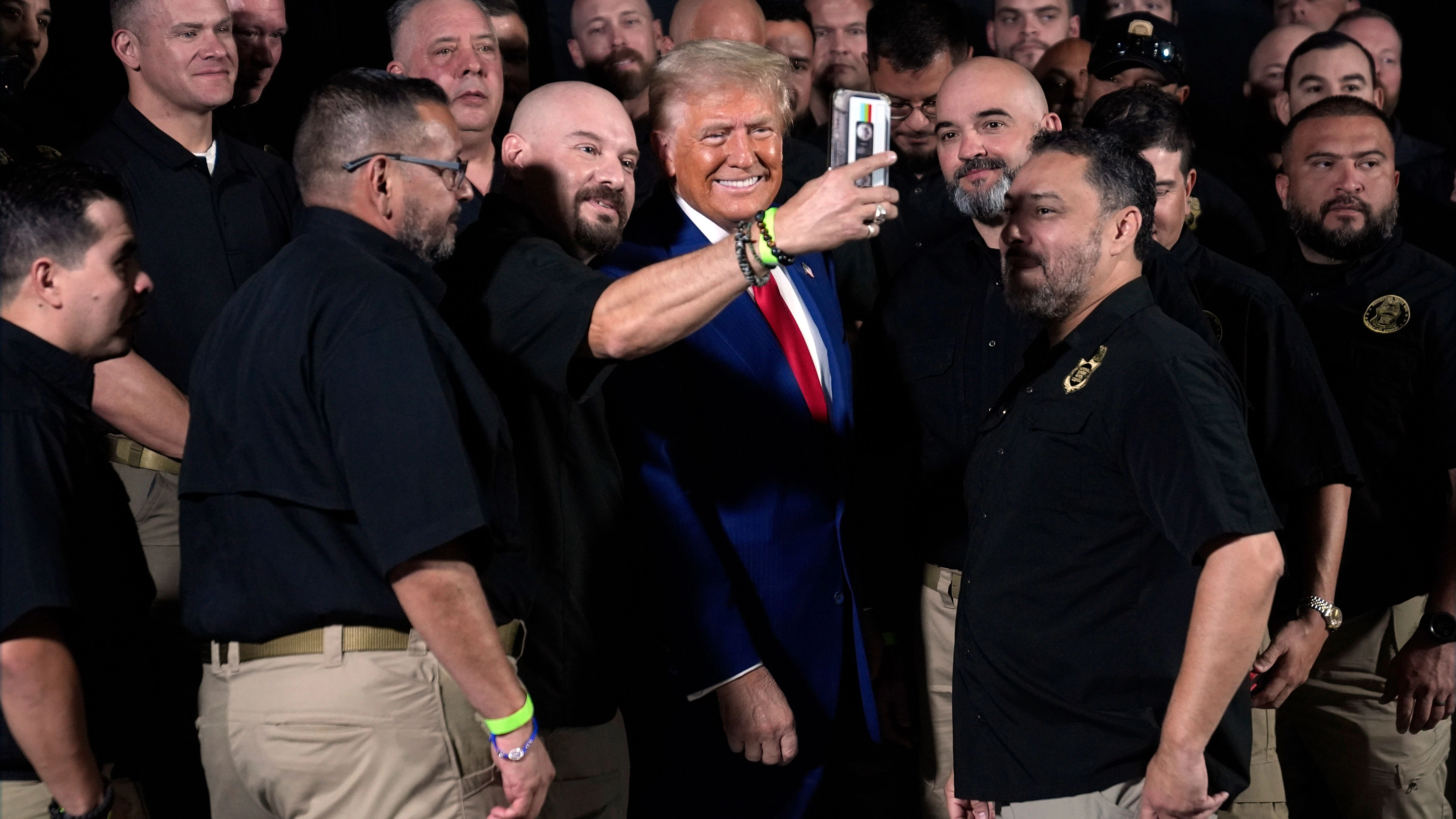 Donald Trump posiert mit Mitgliedern der US-Grenzschutzpolizei für ein Foto.