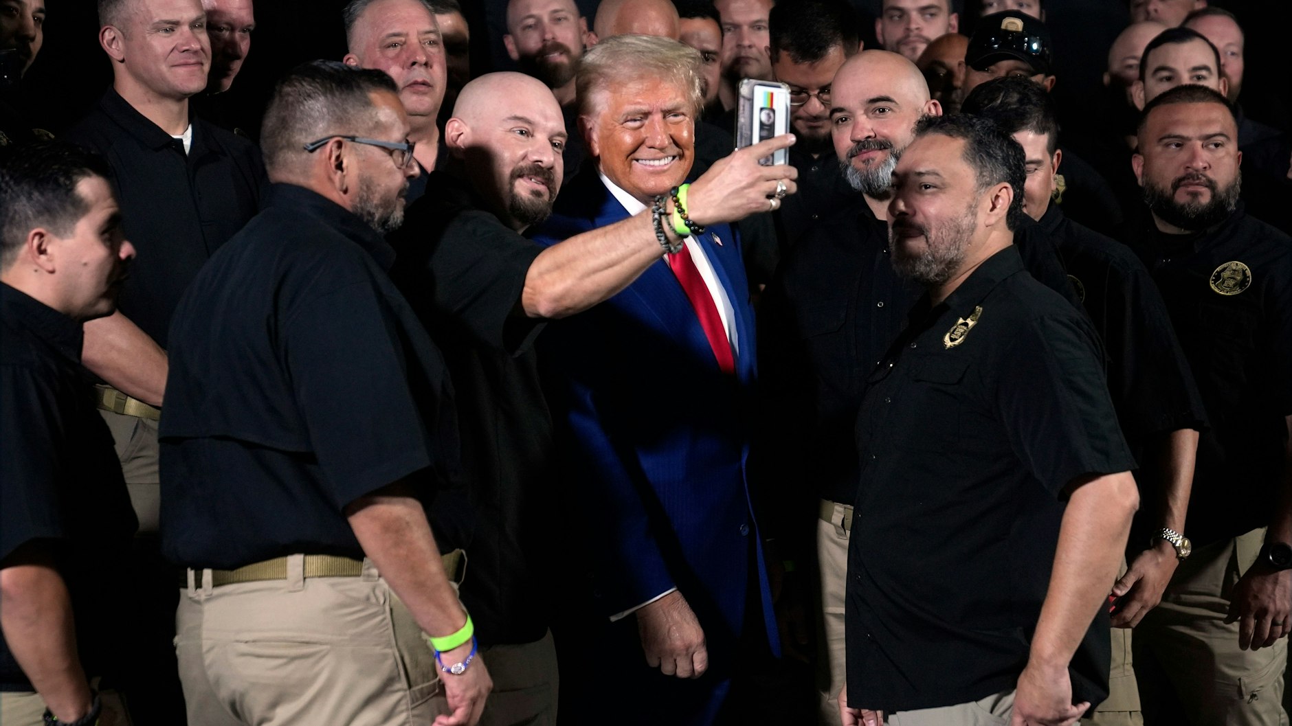 Donald Trump posiert mit Mitgliedern der US-Grenzschutzpolizei für ein Foto.