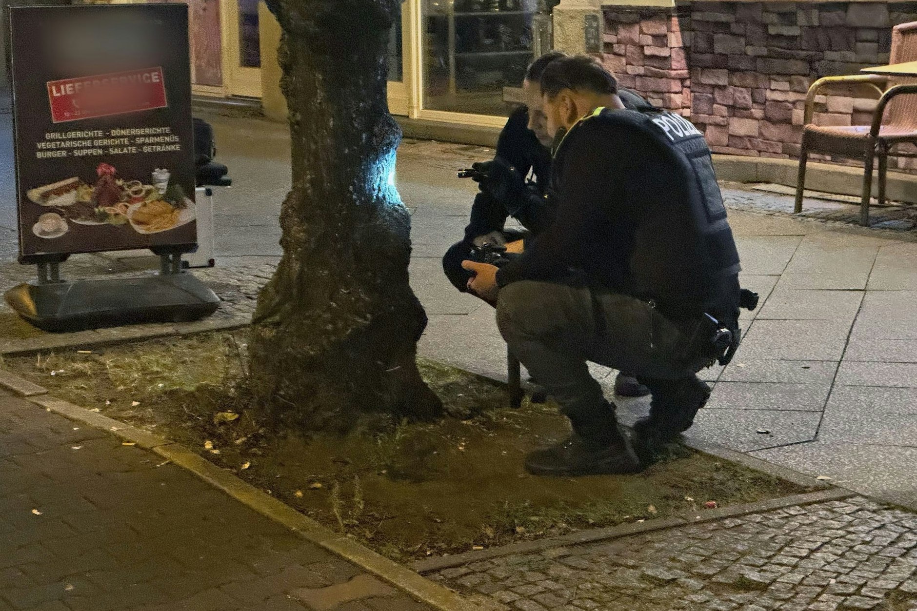 Polizisten begutachten Einschusslöcher von Kugeln neben dem Grillhaus in Reinickendorf. Dort war ein Gast angeschossen worden.