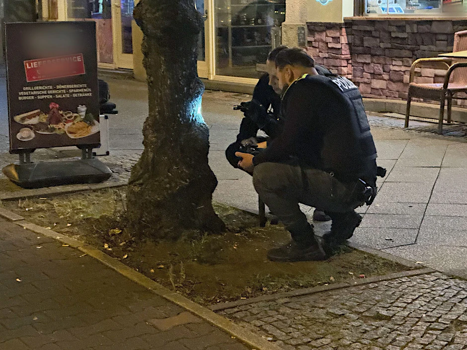 Polizisten begutachten Einschusslöcher von Kugeln neben dem Grillhaus in Reinickendorf. Dort war ein Gast angeschossen worden.