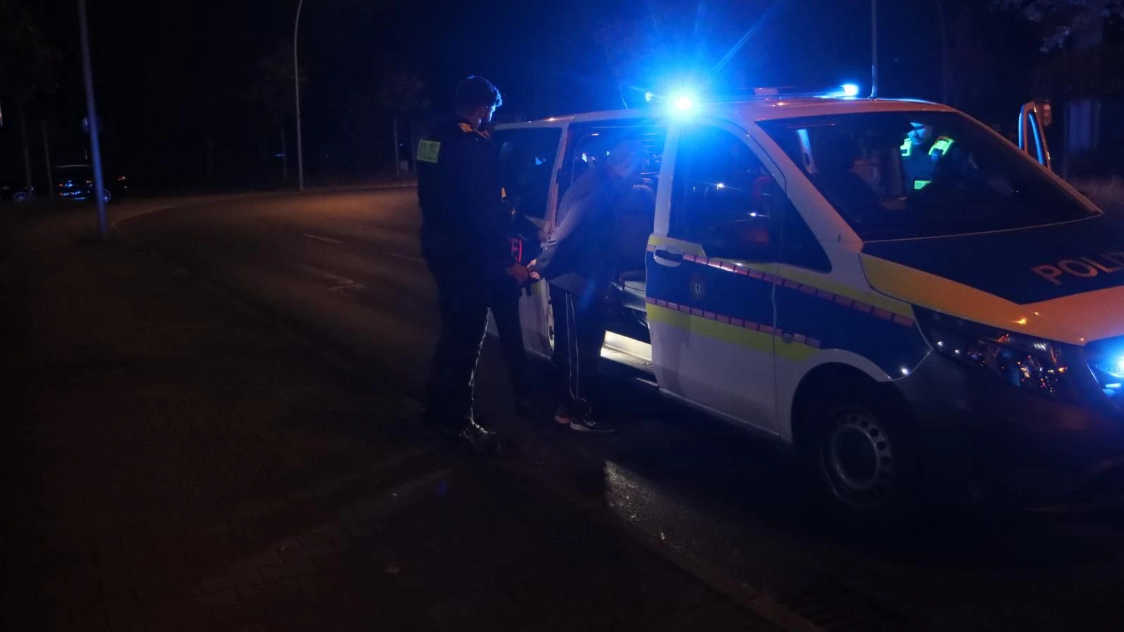Der Fahrer wird in den Polizeiwagen verbracht.