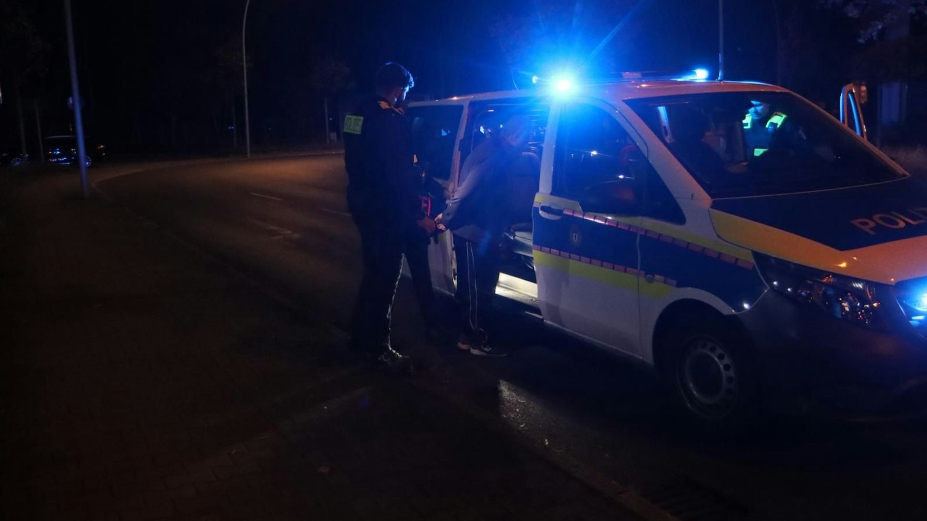 Der Fahrer wird in den Polizeiwagen verbracht.