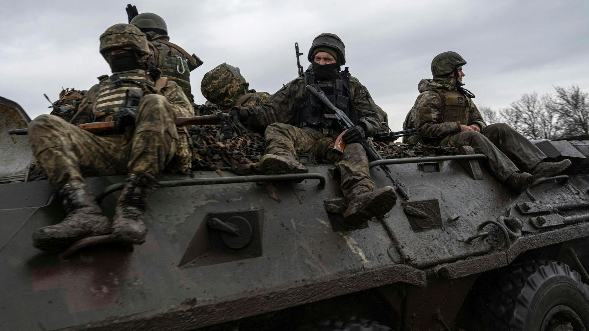 Ukrainische Soldaten fahren mit einem Schützenpanzer in Richtung Frontlinie.