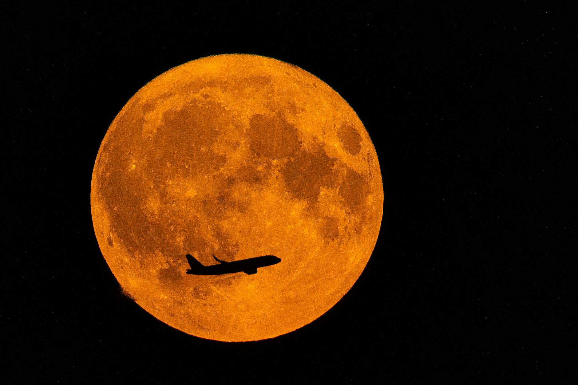 Der Supermond am 19. August 2024 in der Nähe von Stahnsdorf in Brandenburg. Ein vom Flughafen Berlin-Brandenburg ( BER ) gestartetes Flugzeug sieht man im Vordergrund.