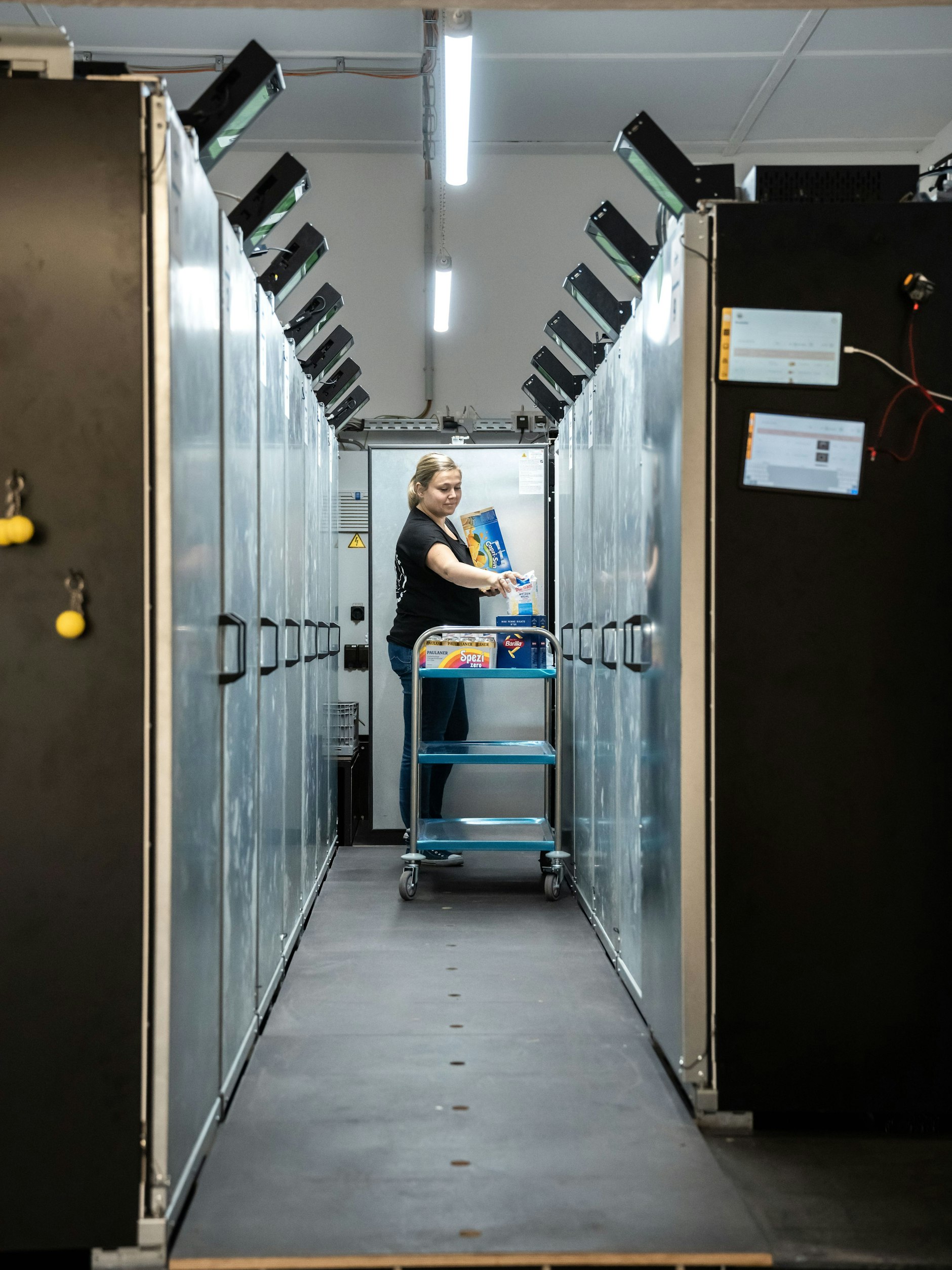 Die Betreiberin von Emmas Kaufhalle füllt die Automaten auf.