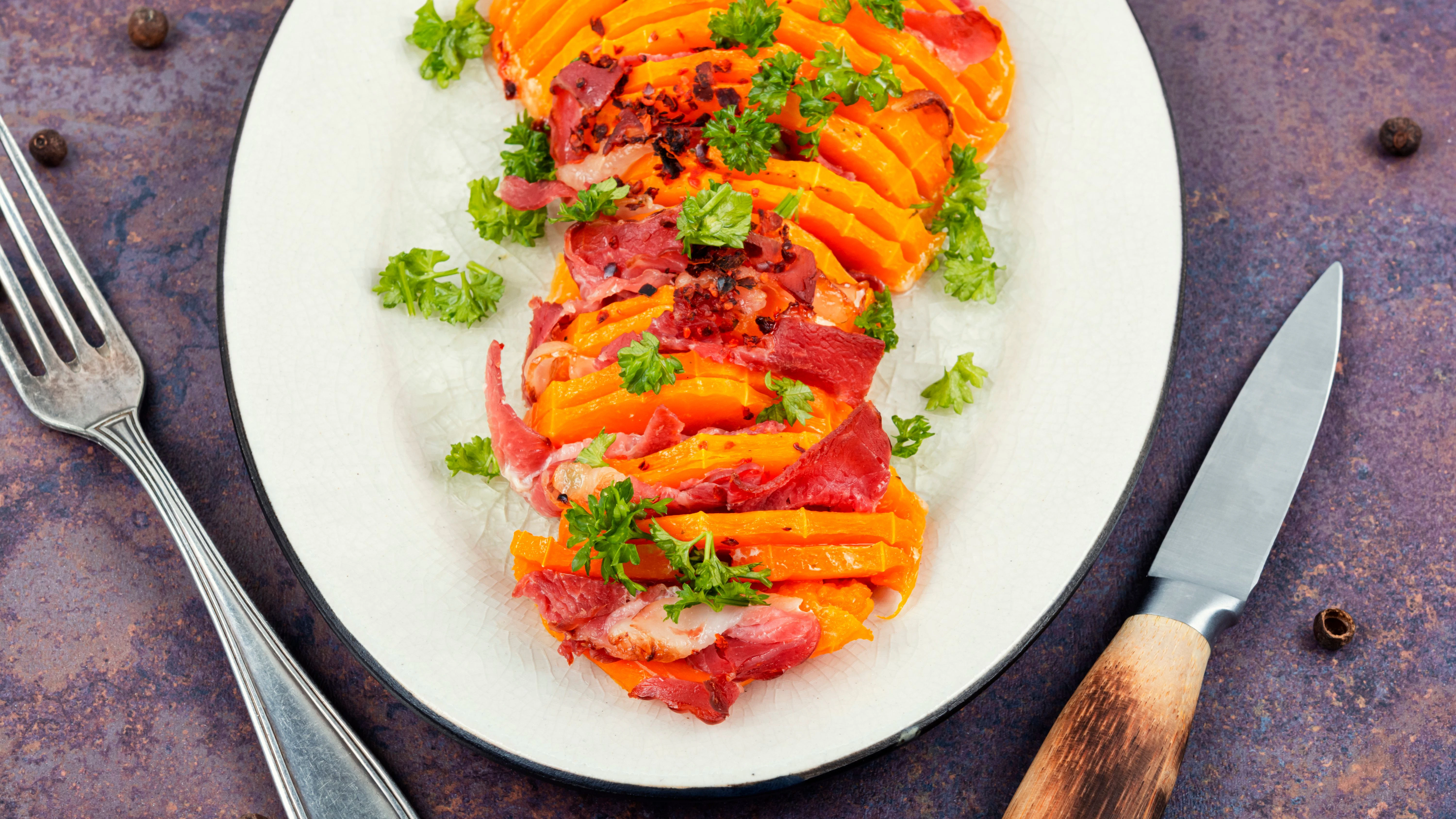 Probieren Sie das Rezept für gebackenen Kürbis mit Speck gleich mal aus.