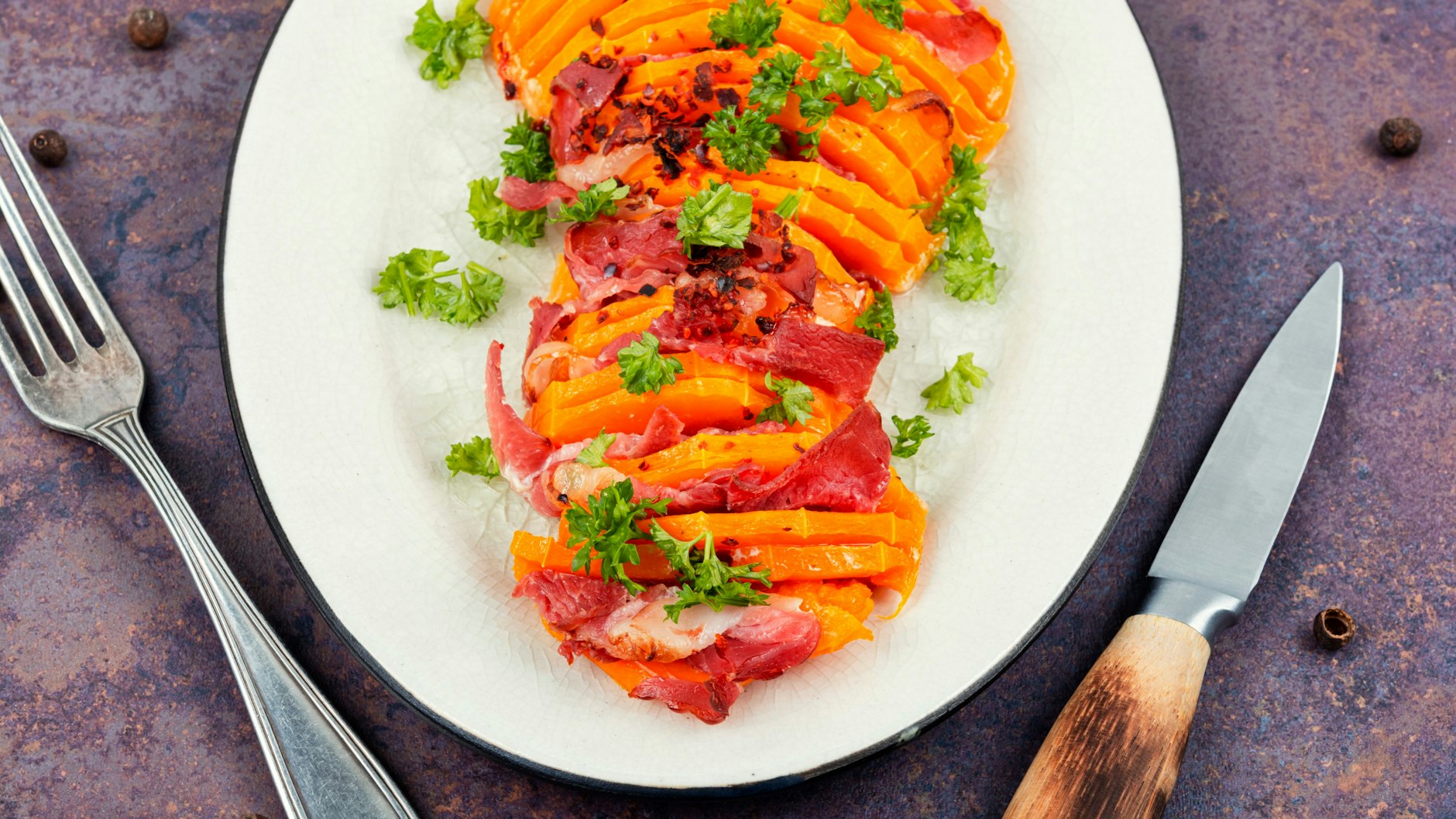 Probieren Sie das Rezept für gebackenen Kürbis mit Speck gleich mal aus.